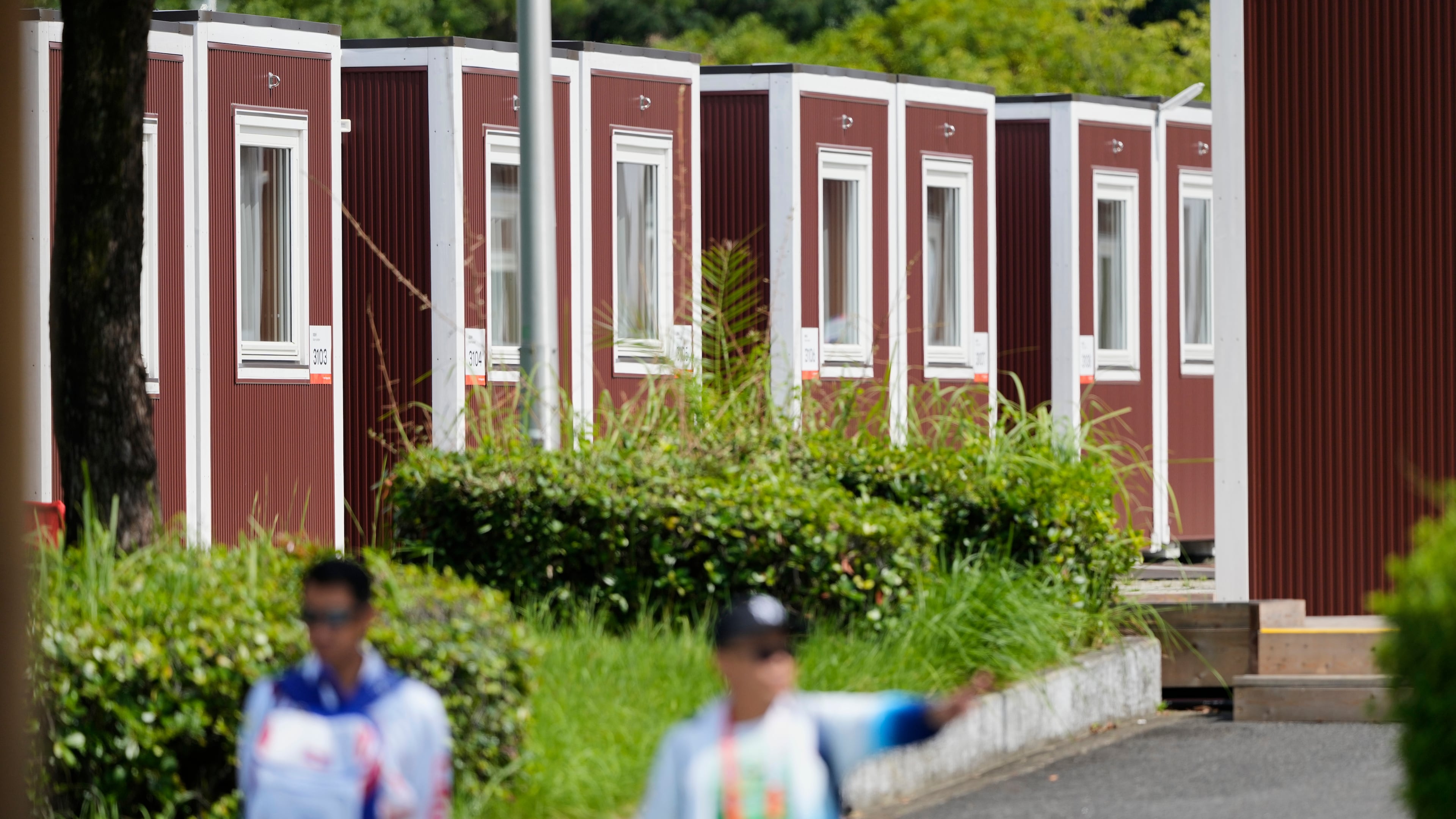 Officials stand outside the athletes accommodation huts at the Athletes Village ahead of the Asian Games Nagoya, Japan, Friday, Sept. 18, 2026. (AP Photo/Dita Alangkara)