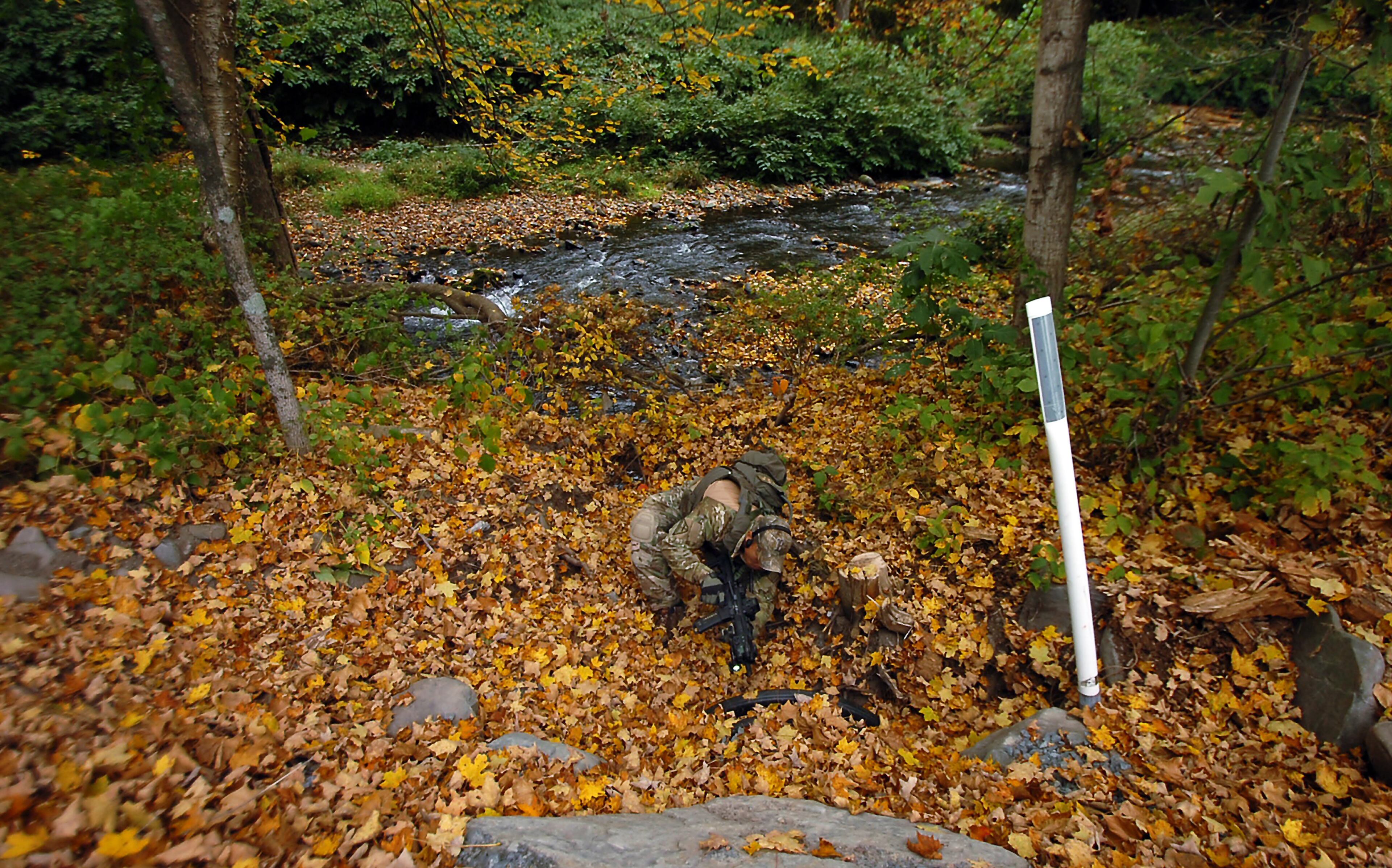 An ATF agents points his weapon towards the inside of a drainage pipe as he searches a section of woods in Price Township, near Canadensis, Pa., Wednesday, Oct. 1, 2014, as the search for suspected killer Eric Frein continues. Tourism officials in the Pocono Mountains say that while visitors are calling to ask about the manhunt for Frein now in its third week very few of them are canceling their hotel and outing reservations during one of the busiest times of the year. (AP Photo/Scranton Times-Tribune, Butch Comegys) WILKES BARRE TIMES-LEADER OUT; MANDATORY CREDIT
