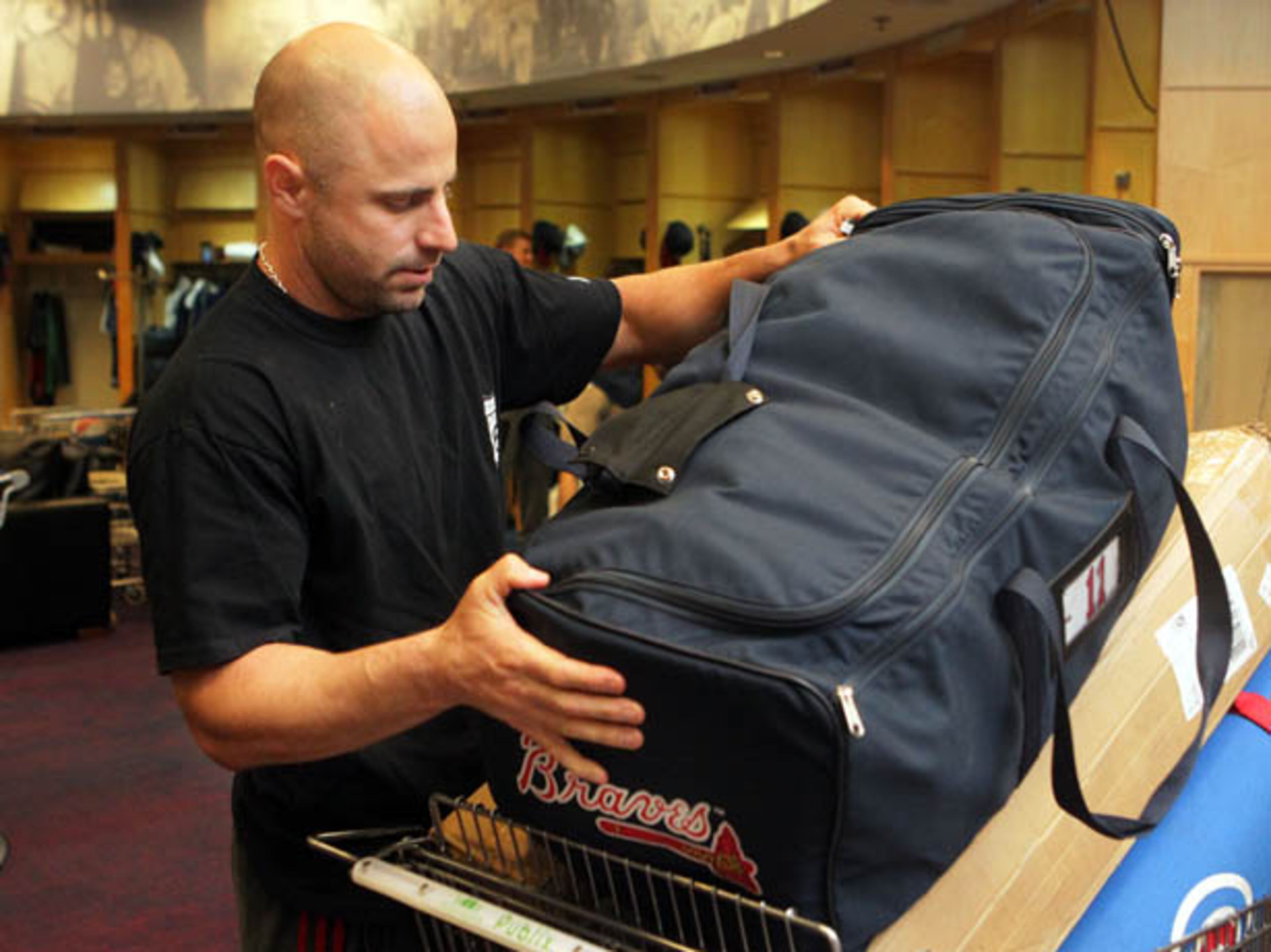 Braves outfielder Reed Johnson packs a bag on to a cart after cleaning out his locker.
