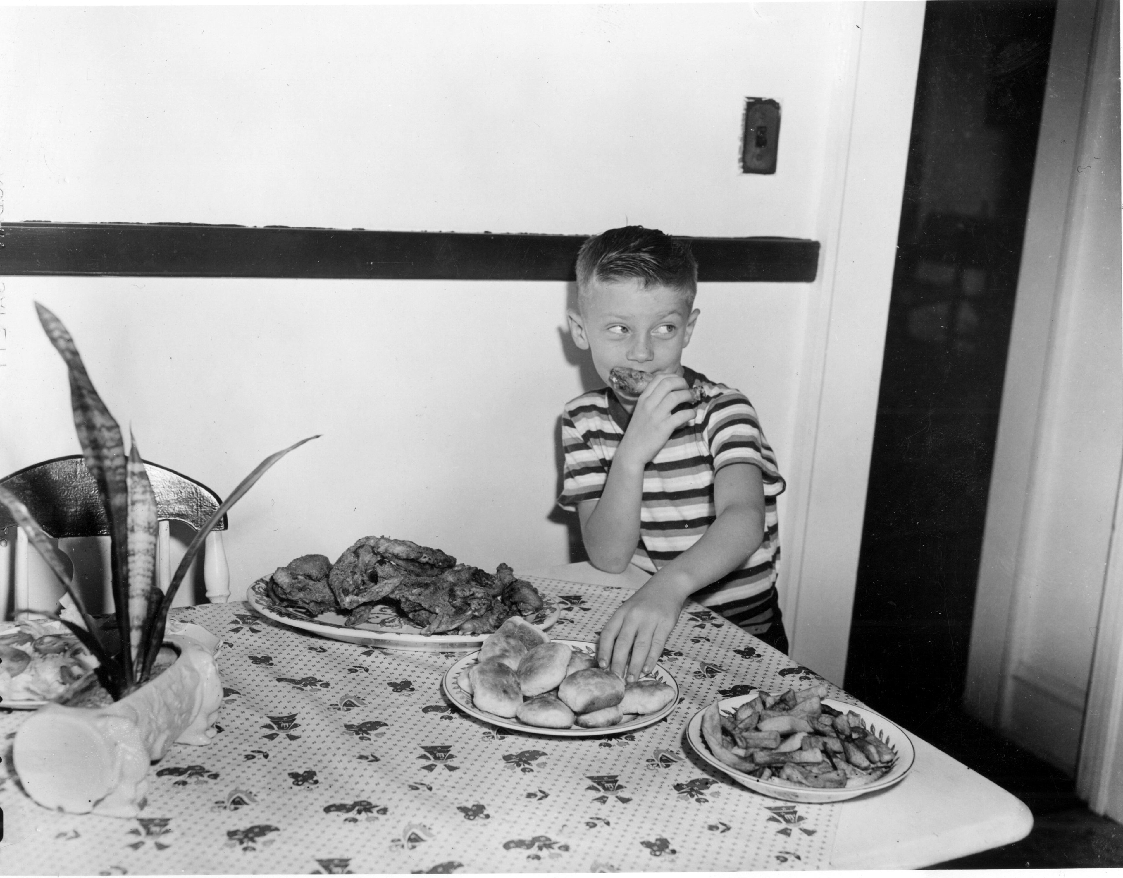 All part of a REAL housewife's busy day: This resourceful youngster, identified as Freddie, sneaks a piece of chicken and a biscuit before his mother can get from the kitchen to the dining room. Not that any of your MyAJC.com Flashback Foto staffers would know anything about pulling such hijinks when they were kids. Certainly not. Ahem. Well, then, moving right along...