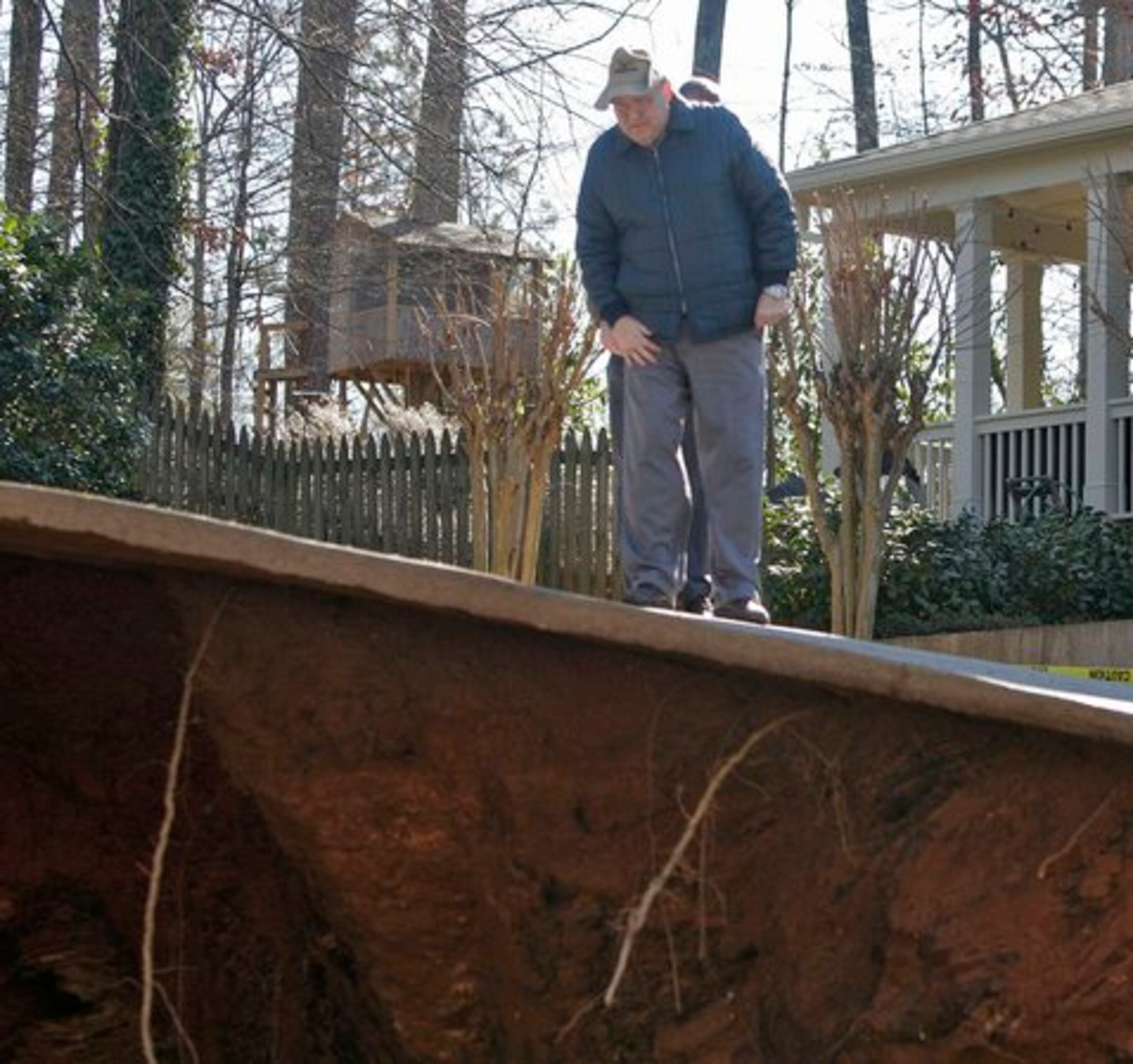 City engineer Richard King peeks over the edge of the undermined driveway. Beyond the stability of the house, the city is concerned the sinkhole could reach the street and block access for other residents, officials added.