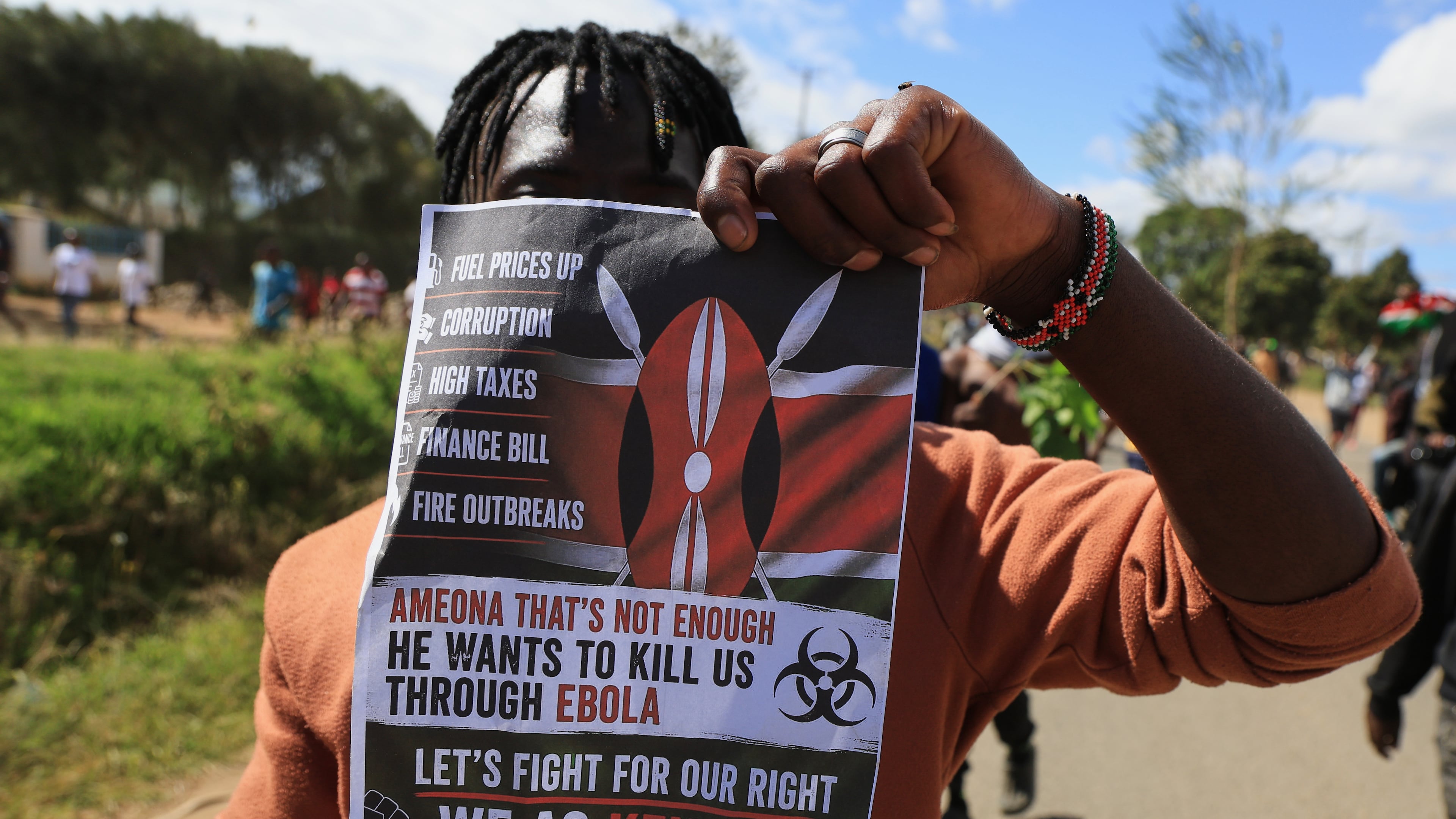 A protester holds up a placard during a demonstration against a proposed Ebola quarantine center to be established by the United States at Laikipia Air Base in Nanyuki, Kenya, Monday, June 1, 2026. (AP Photo/Andrew Kasuku)