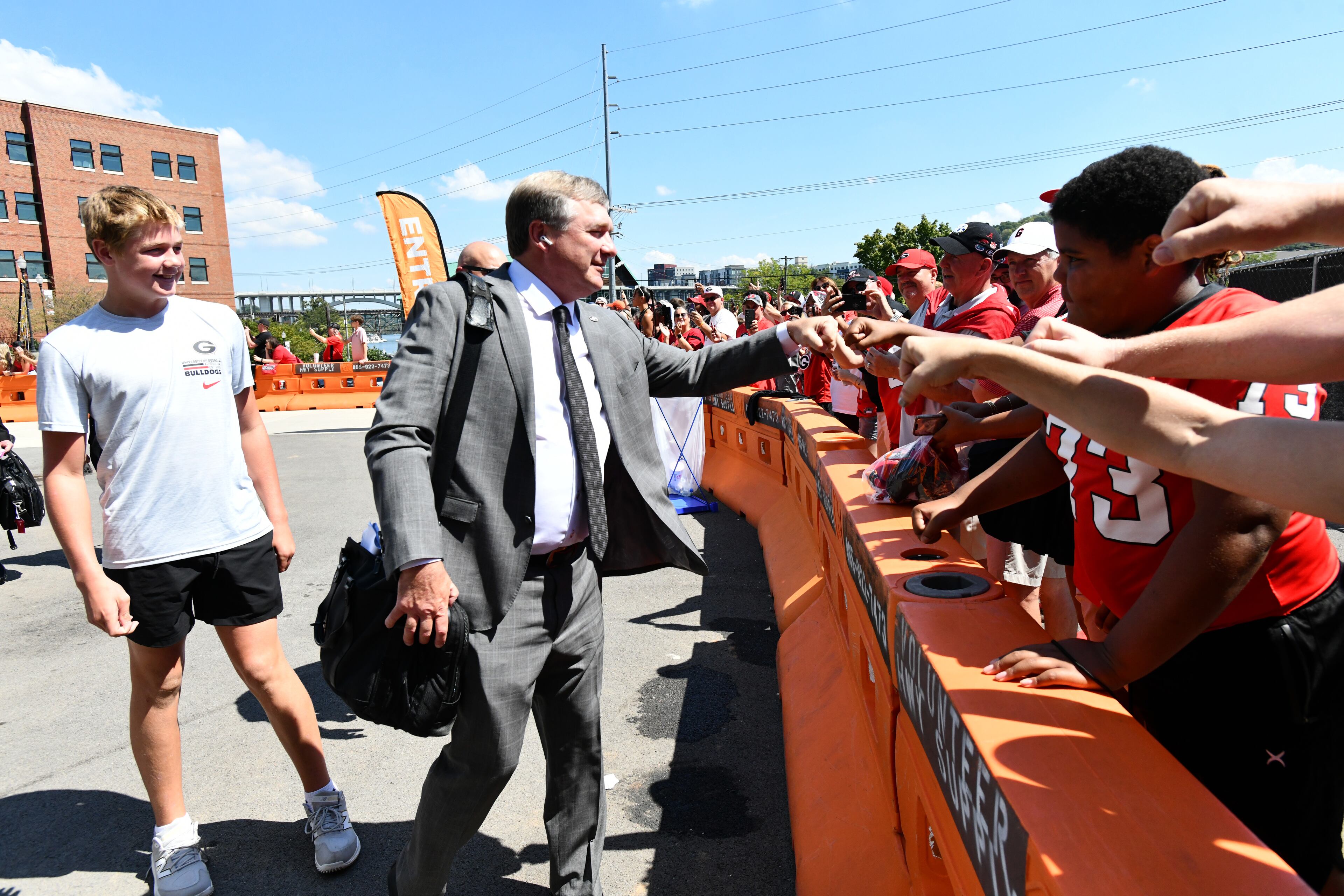 Andrew Smart joins his dad, Georgia coach Kirby Smart to greet Bulldogs fans who made the trek to Neyland Stadium for Saturday's game against Tennessee. (Hyosub Shin/AJC)