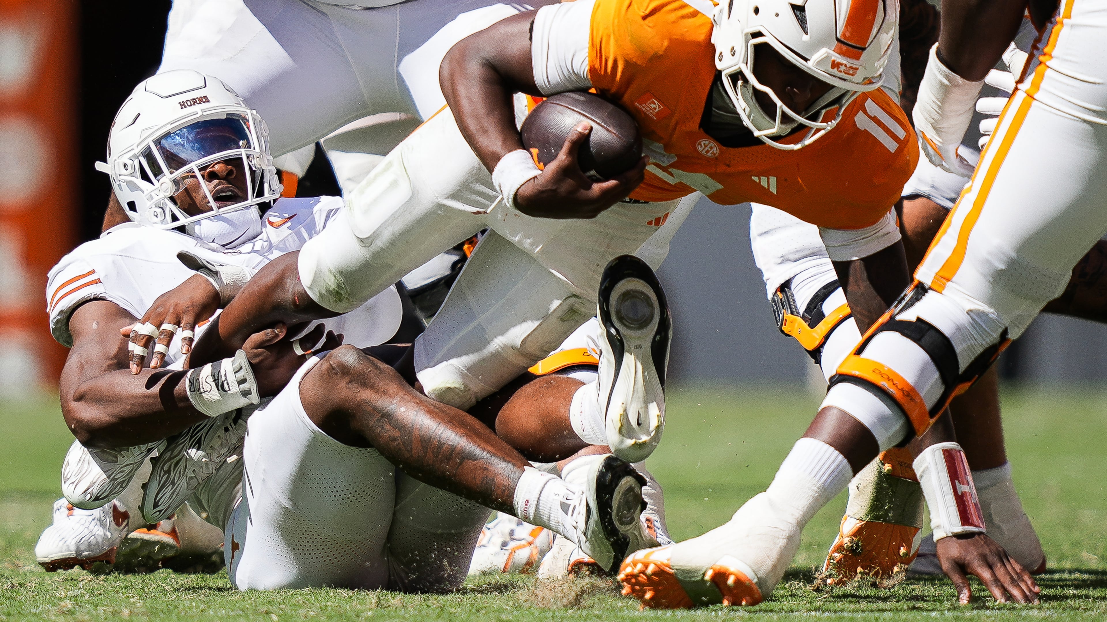 Texas defensive end Colin Simmons (1) brings down Tennessee quarterback Faizon Brandon (11) during the second half of an NCAA college football game in Knoxville, Tenn., Saturday, Sept. 26, 2026. (Sara Diggins/The San Antonio Express-News via AP)