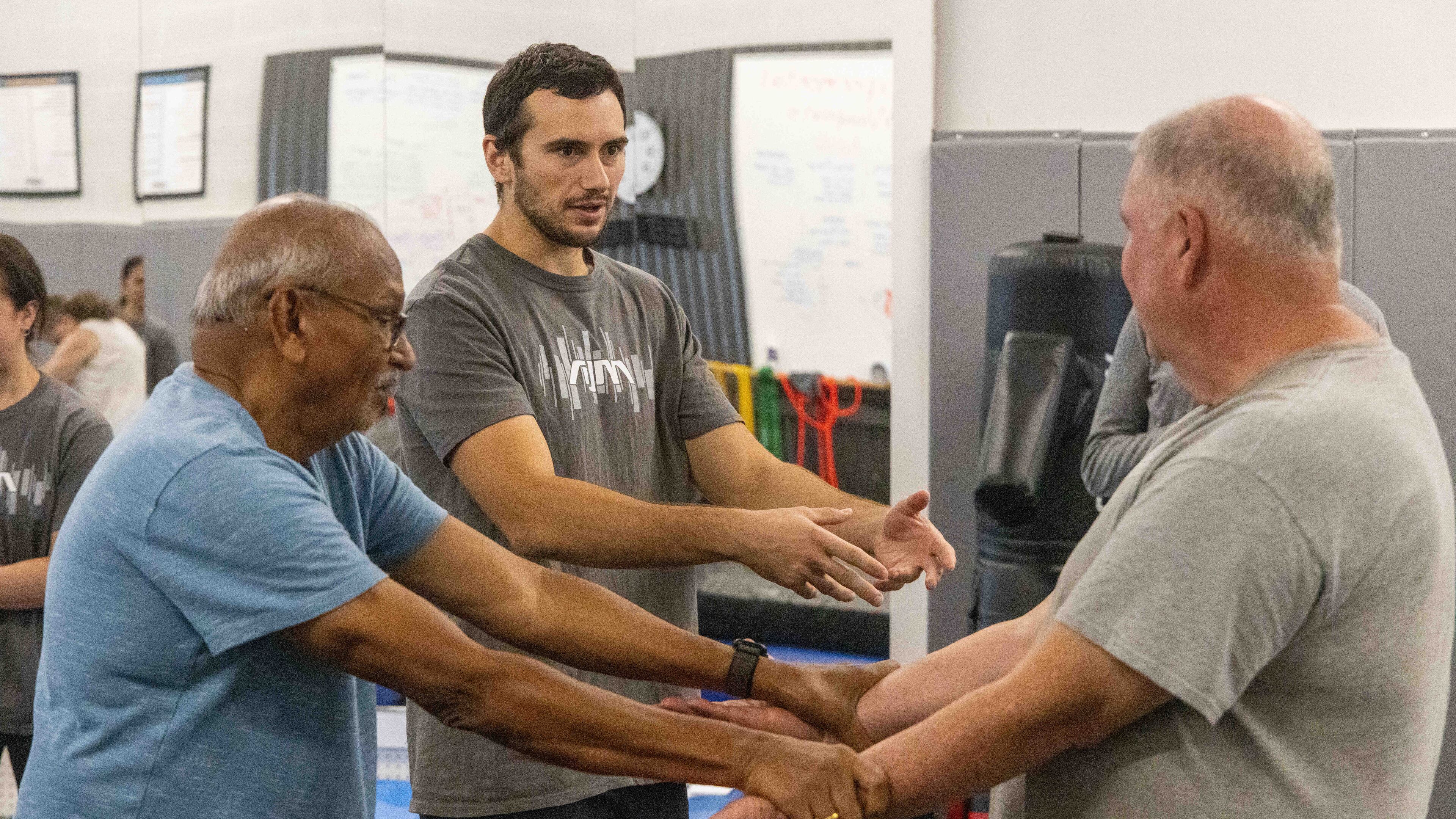 Atlanta Judo Midtown's Jacob Becerra (center) gives Shankaran Mahadevan (left) and Jim Tebbel instruction during the new 6-week Strong and Stable, Safe-Falling Program for Seniors.(Phil Skinner for the AJC)