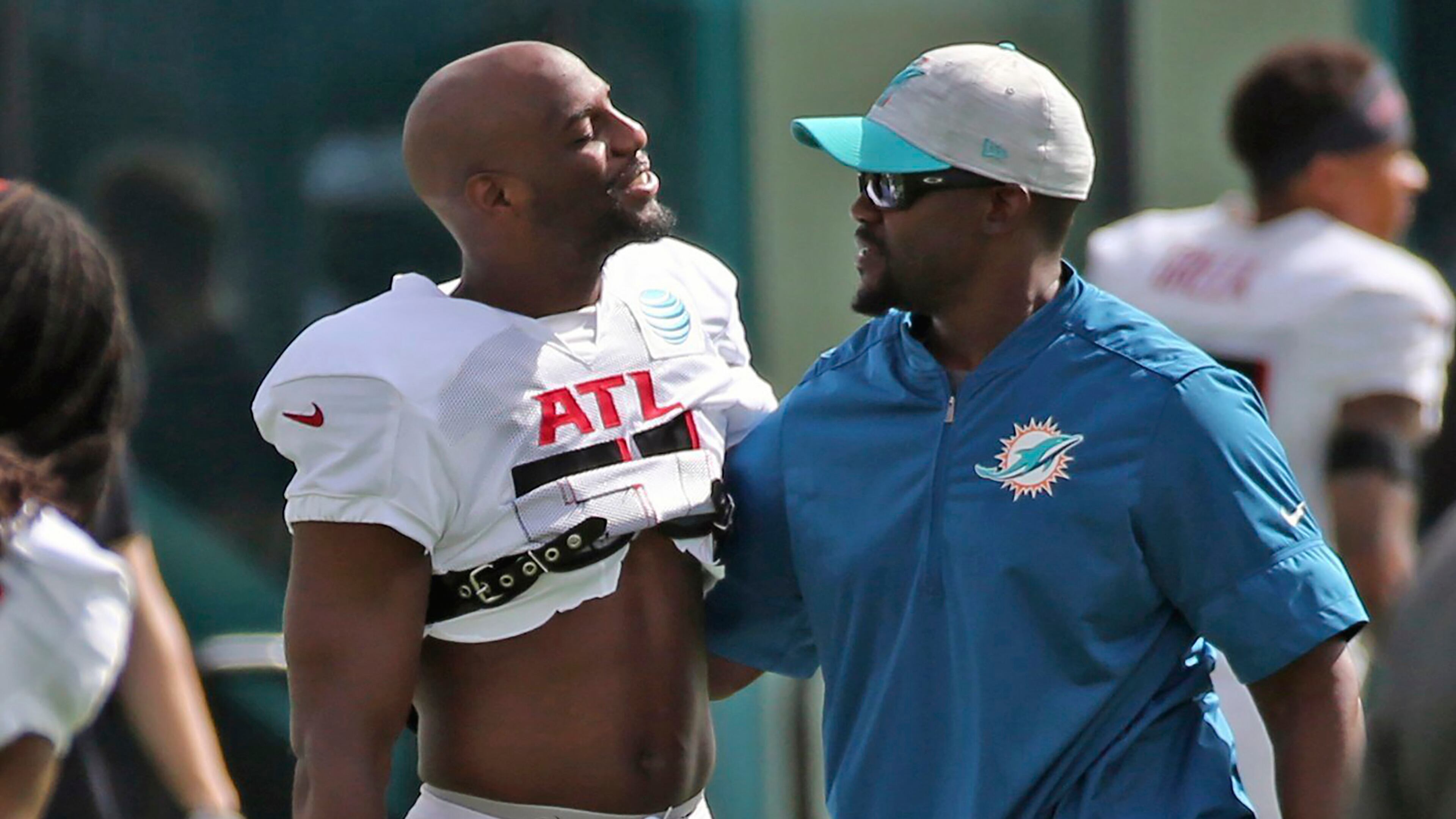 Atlanta Falcons cornerback Duron Harmon (left) and Miami Dolphins coach Brian Flores greet one another during a joint training camp practice at the Dolphins training facility Wednesday, Aug. 18, 2021, in Miami Gardens, Fla. (Charles Trainor Jr./Miami Herald)