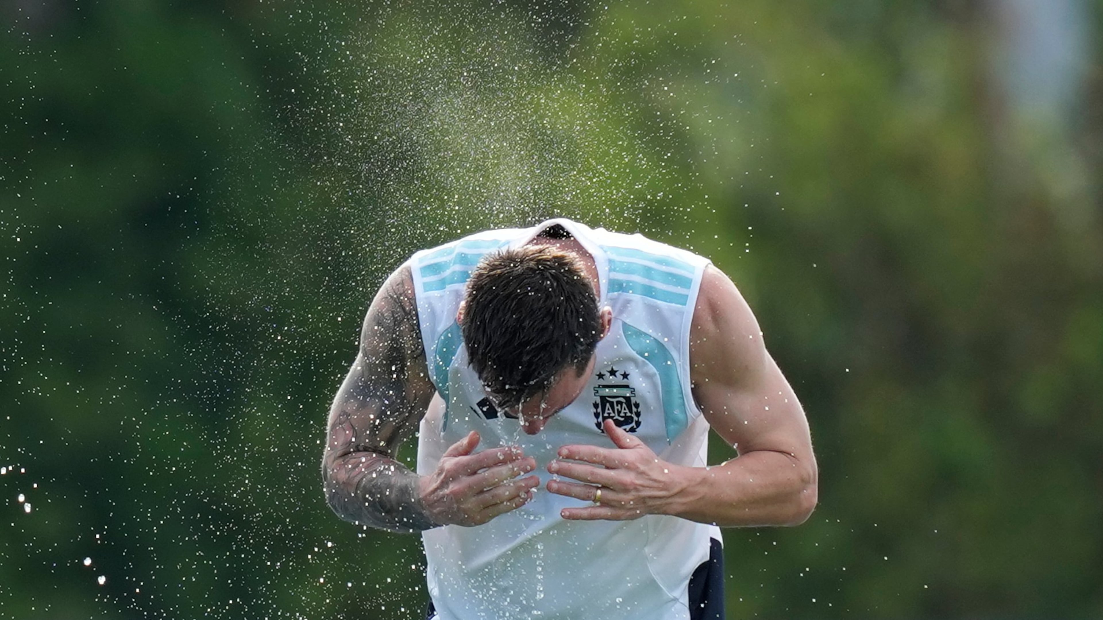 Argentina's Lionel Messi spalshes water on his head to cool down during a training session on the eve of the team's World Cup round of 32 soccer match against Cape Verde, Thursday, July 2, 2026, in Fort Lauderdale, Fla. (AP Photo/Rebecca Blackwell)