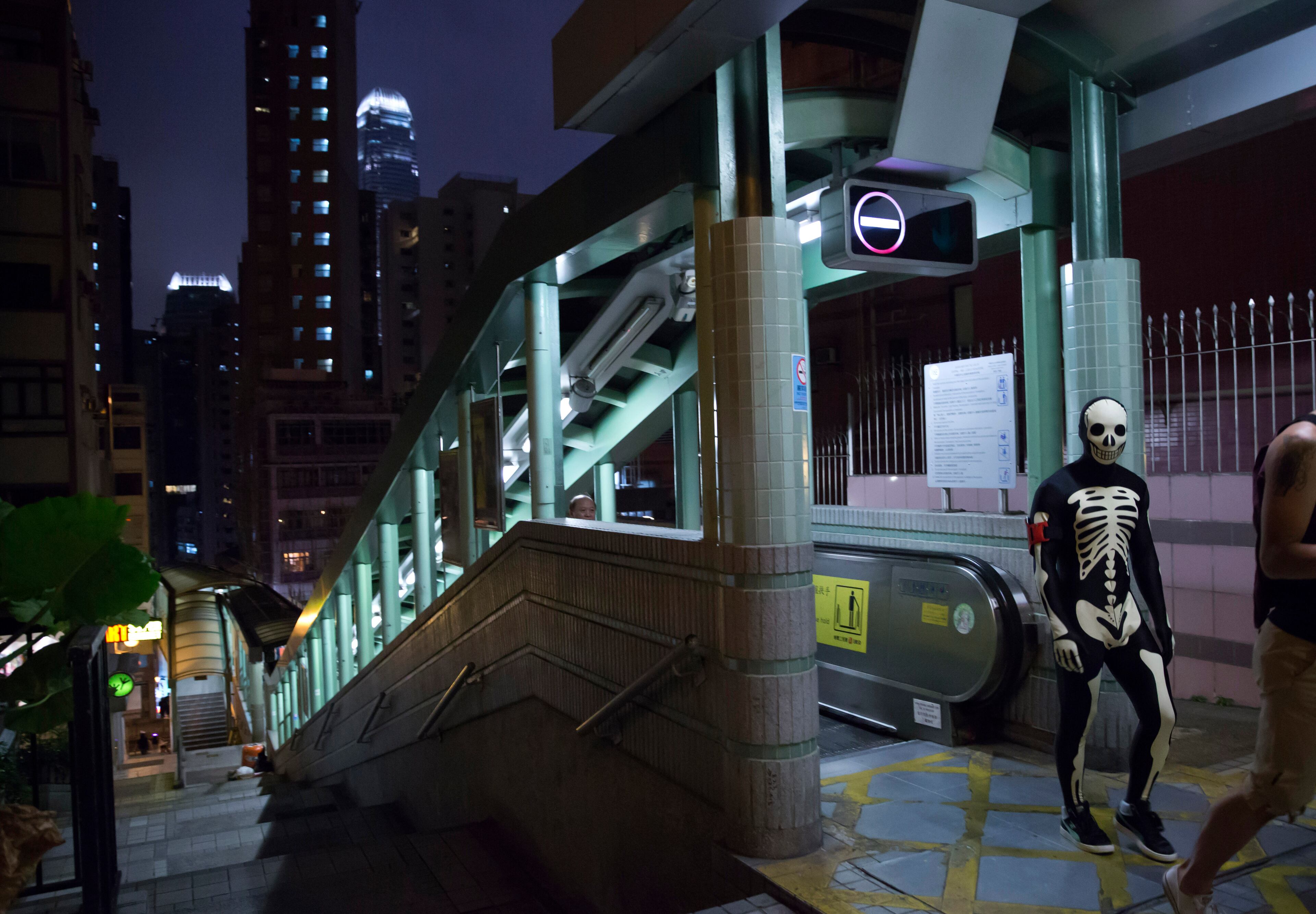 A man dressed in a skeleton costume, walks from an escalator during celebrations for the Halloween festival in Hong Kong, Saturday, Oct. 31, 2015. (AP Photo/Kin Cheung)