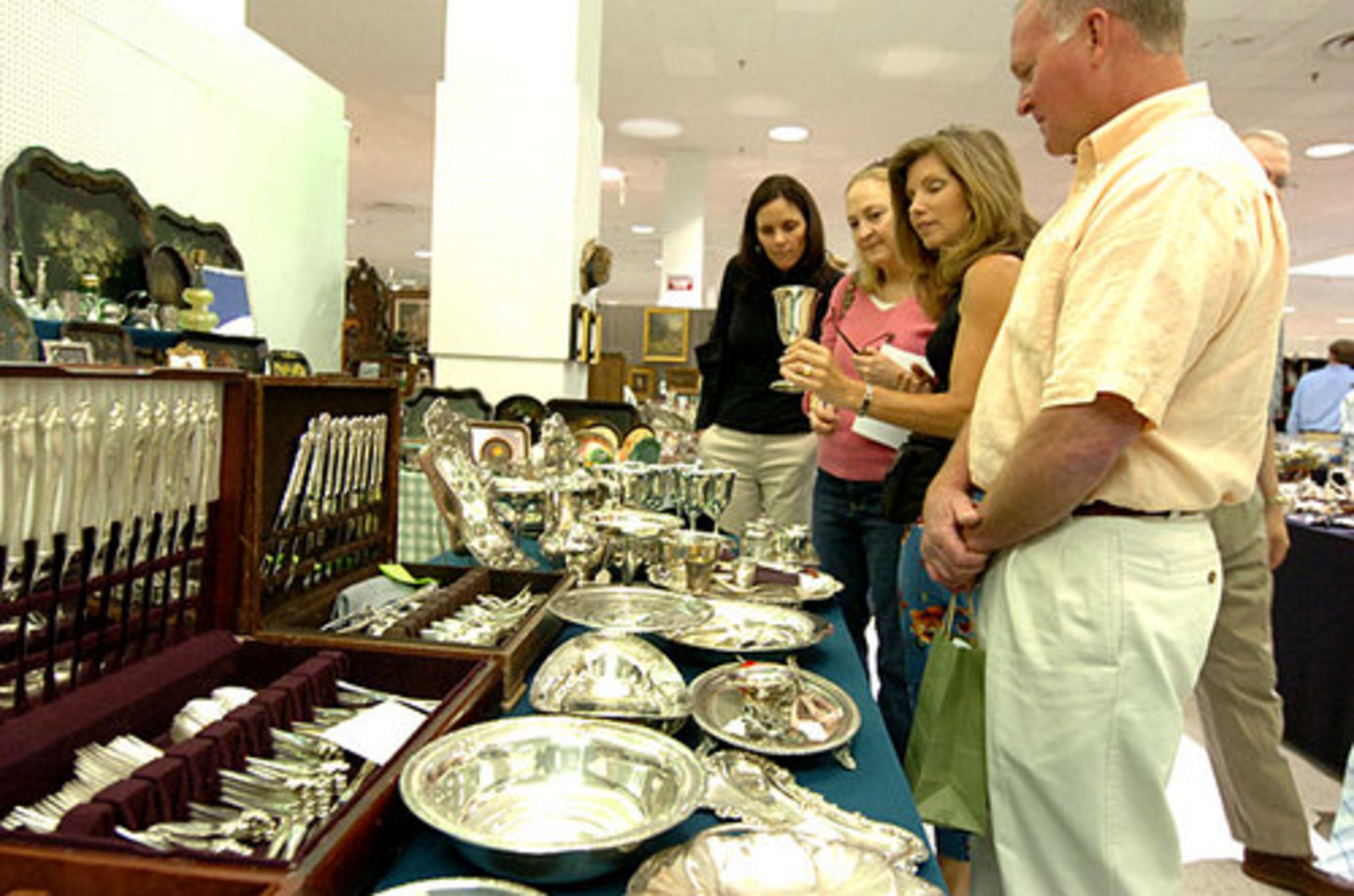 Duvall Fuqua (left), Susannah Dryman (2nd from left), Eisner and Taylor Averett look at silver. Vendors at the market sell everything from silver services to armoires and antique linen napkins.