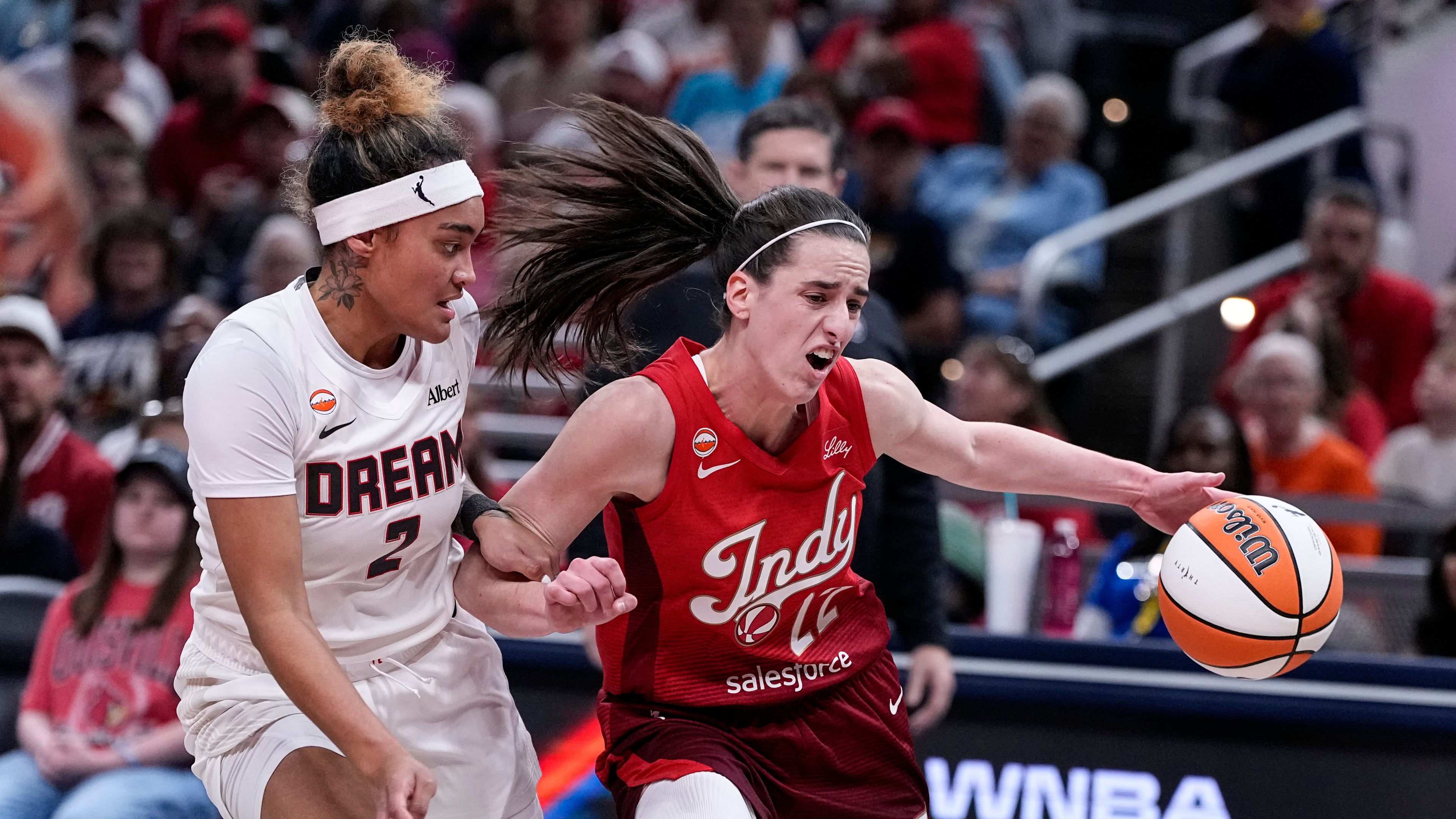 Indiana Fever guard Caitlin Clark (22) drives on Atlanta Dream guard Te-Hina Paopao (2) in the first half of a WNBA basketball game in Indianapolis, Thursday, June 18, 2026. (AP Photo/Michael Conroy)
