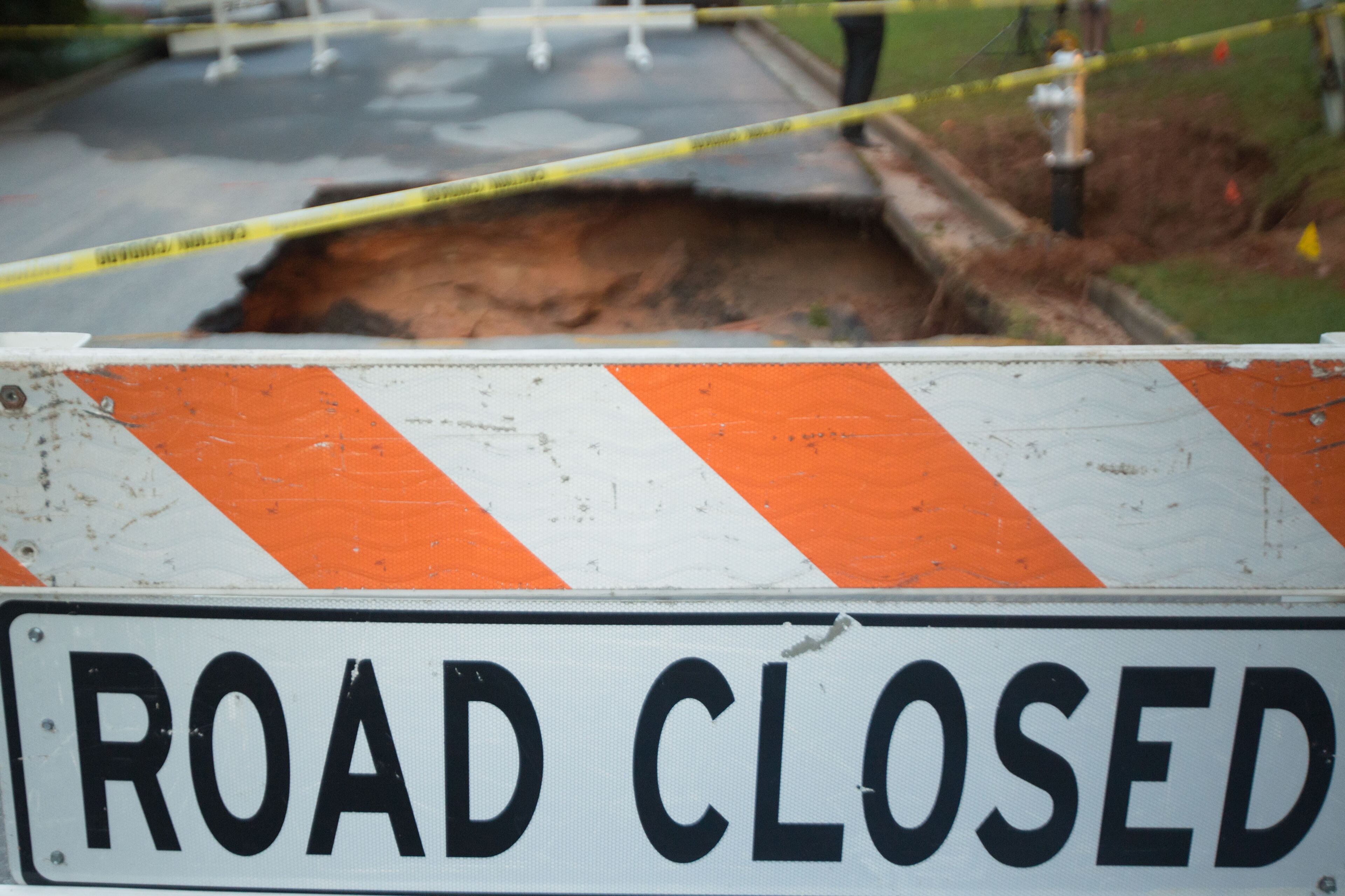 Part of the road collapsed Tues., July 28, 2015, after a driver hit a fire hydrant on Roxburgh Drive in Roswell, Ga. BRANDEN CAMP / SPECIAL