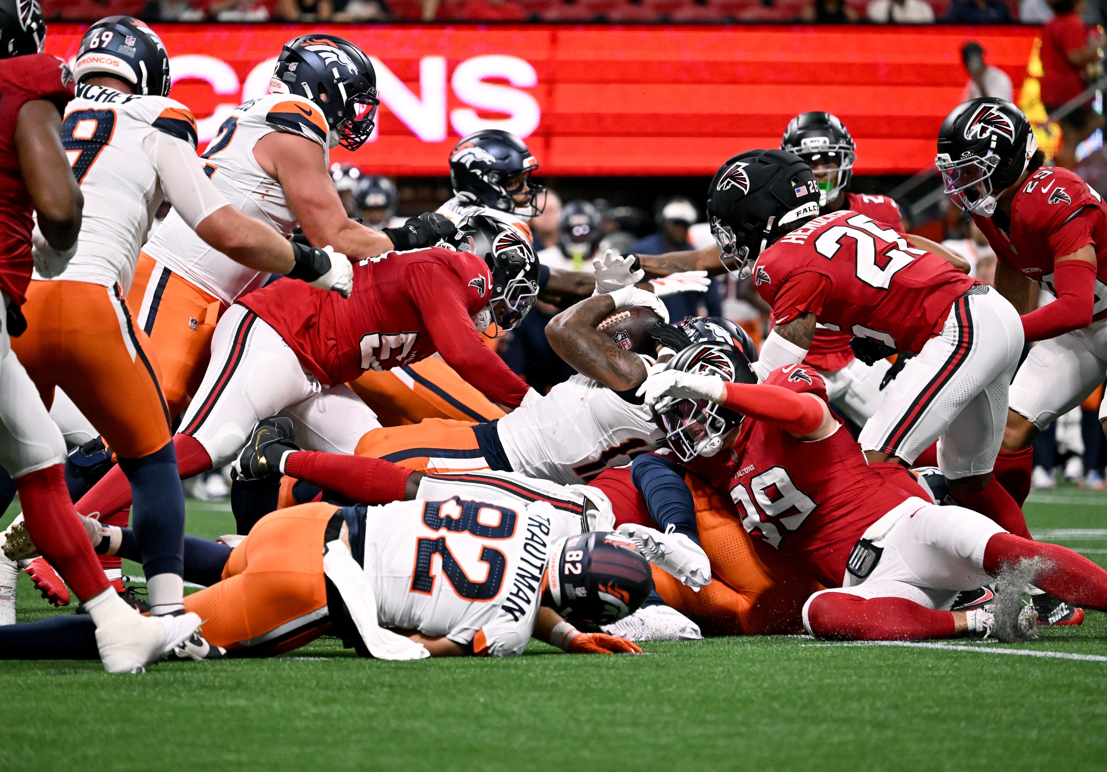 Broncos running back RJ Harvey (center) pushes for yardage against the Falcons during their preseason game at Mercedes-Benz Stadium on Friday, Aug. 14, 2026, in Atlanta. (Hyosub Shin/AJC)