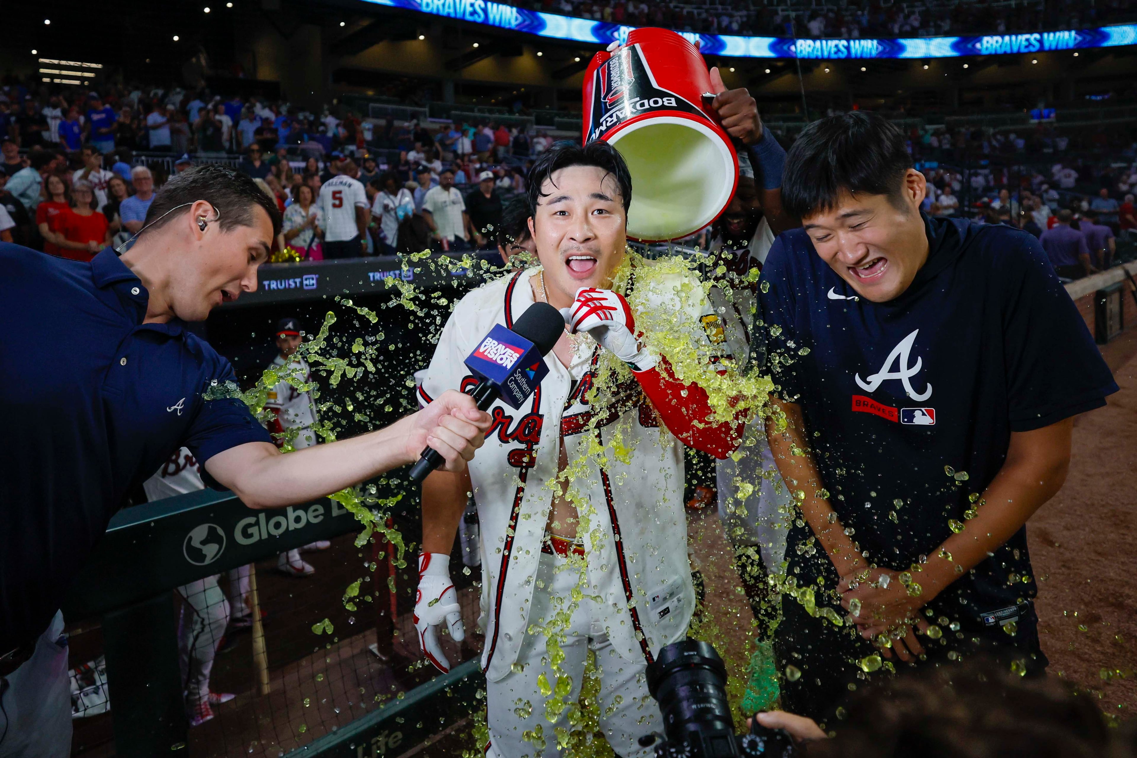 Braves shortstop Ha-Seong Kim (along with his interpreter and BravesVision's Wiley Ballard) got an early postgame shower Wednesday. (Miguel Martinez/ AJC)