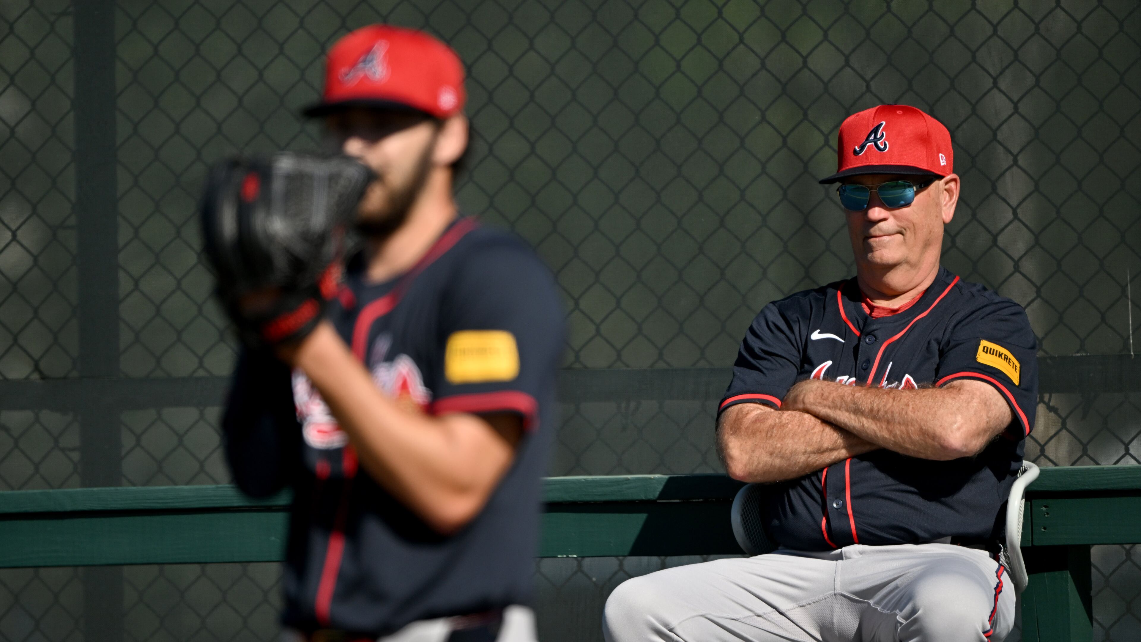 Atlanta Braves manager Brian Snitker (right) watches as pitcher Ian Anderson (foreground) prepares to throw a ball during spring training workouts at CoolToday Park, Monday, February 17, 2025, North Port, Florida. (Hyosub Shin / AJC)