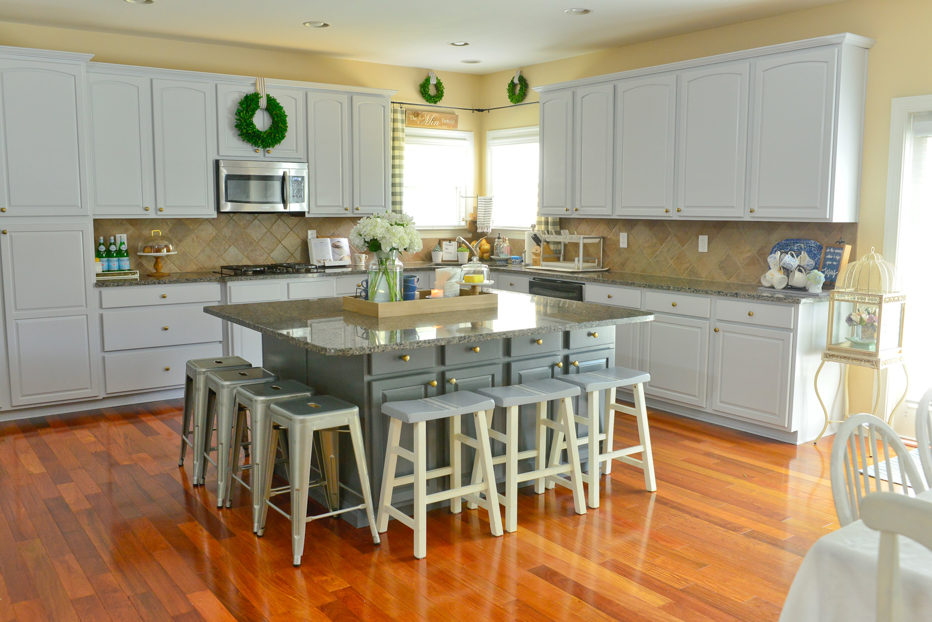 Kitchen: The Cumming kitchen includes an oversized island with granite countertops stools for the family's three young children and their friends. The kitchen table was in Yuni's childhood home, and she has since repainted to match her decor.