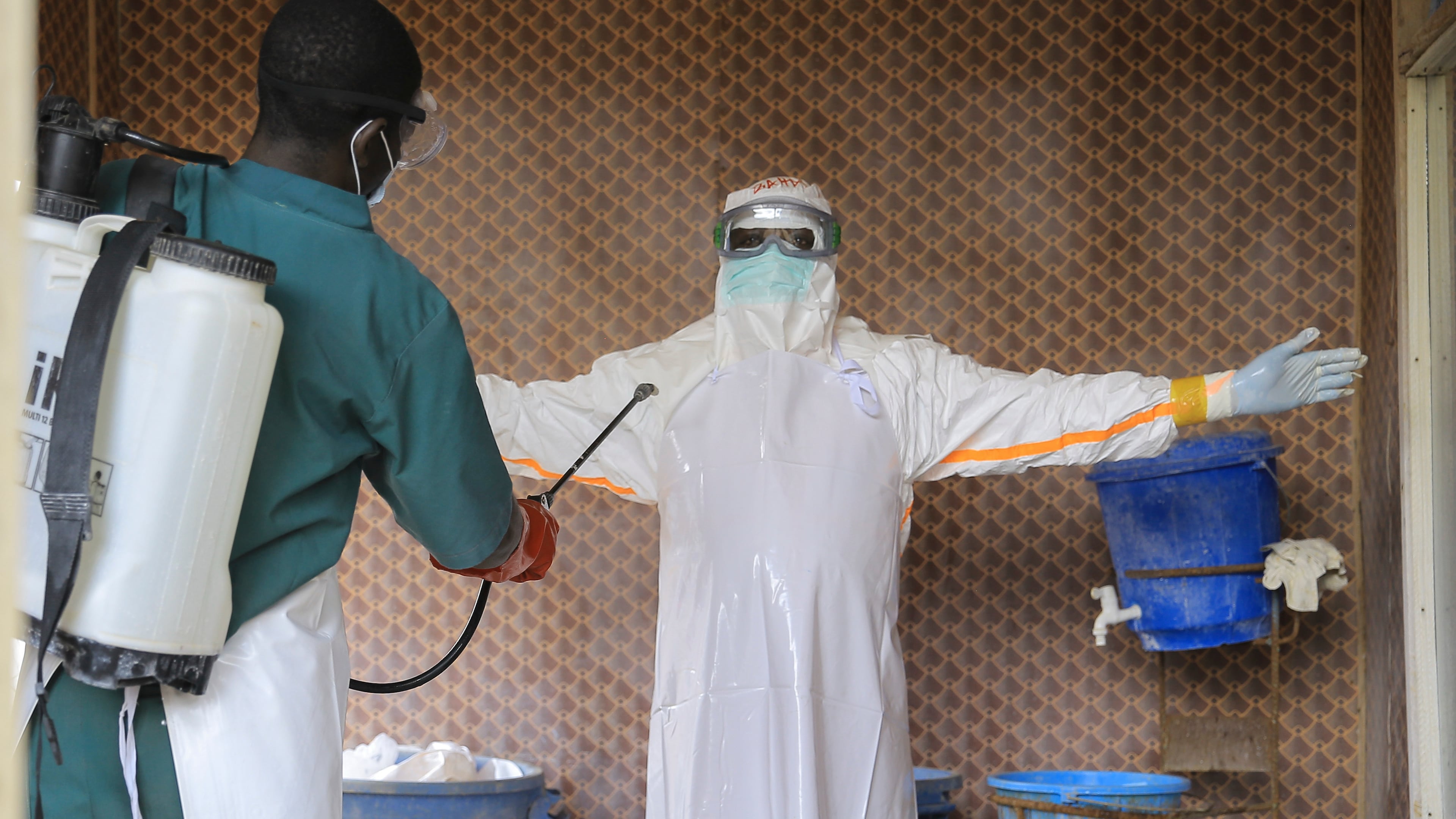 A healthcare worker in protective clothing is disinfected by a colleague inside a treatment center for Ebola patients in Beni, North Kivu province, eastern Congo, Saturday, Sept. 26, 2026. (AP Photo/Sebastien Kitsa Musayi)