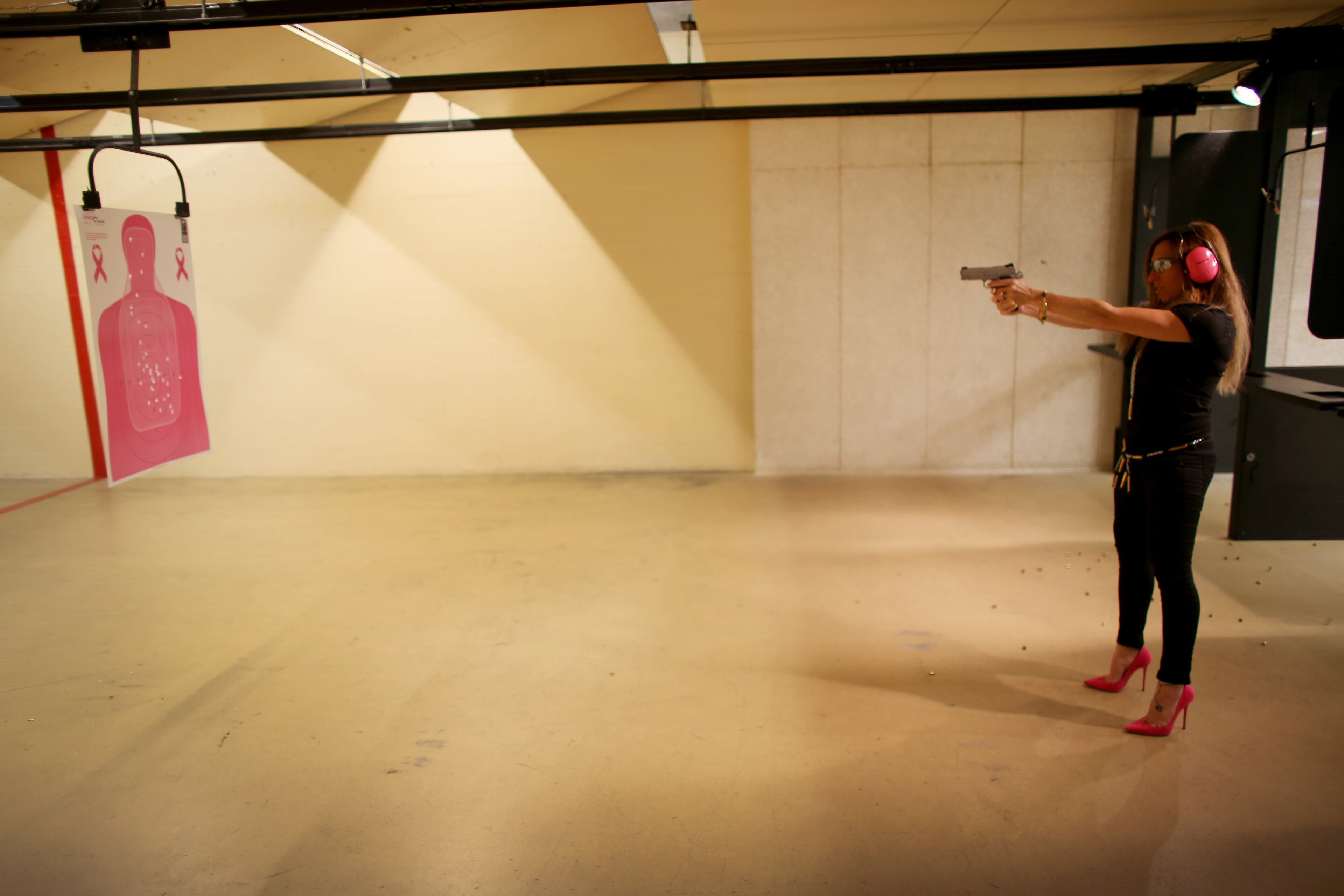 Susan Kushlin shoots her pistol while wearing a shirt, chain belt and bracelet from Gun Girls Inc.