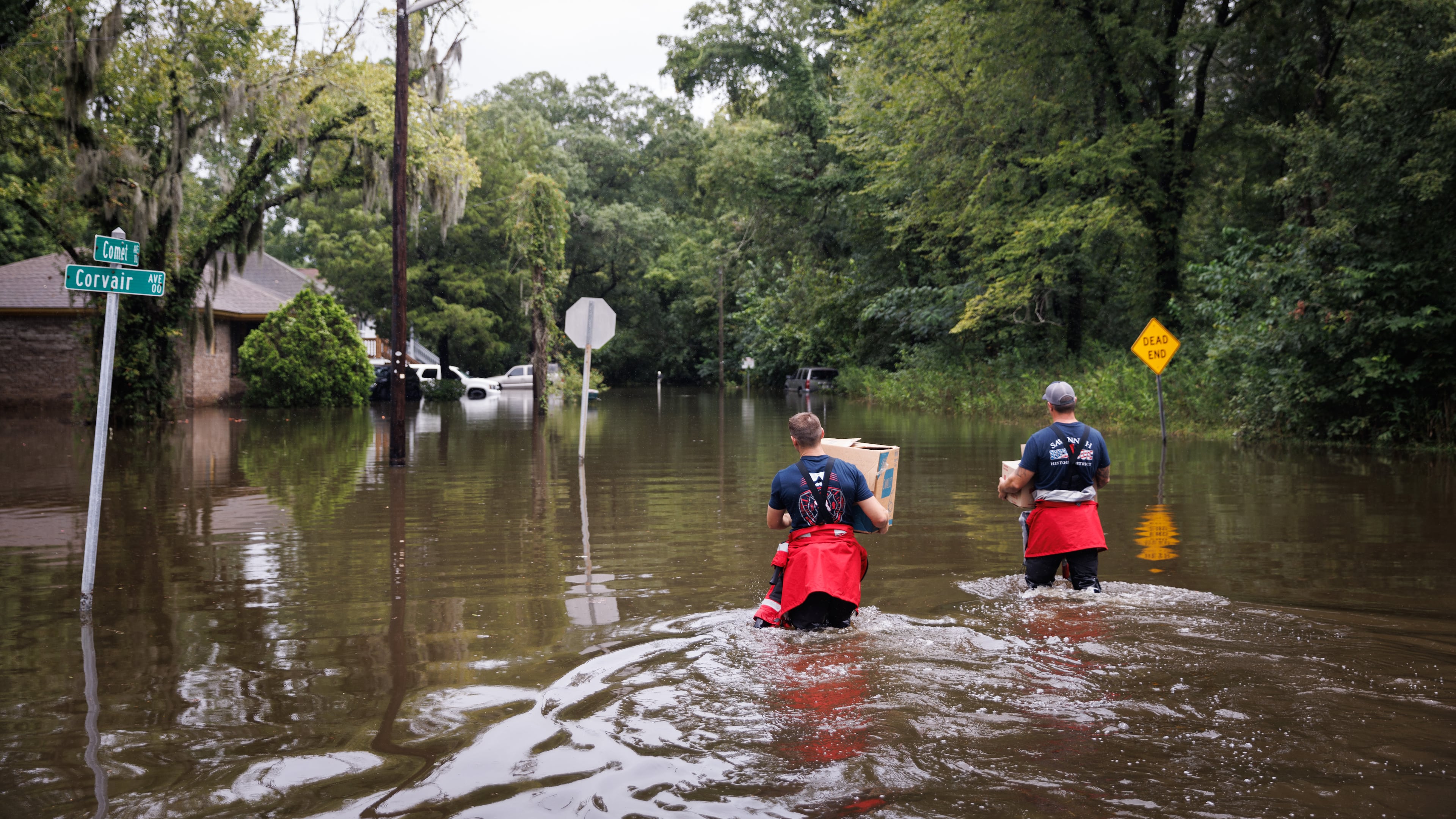 Savannah firefighters wade into floodwaters to deliver food to residents stuck in their homes amid flooding after Hurricane Debby struck Georgia in August 2024. (Dustin Chambers/The New York Times)