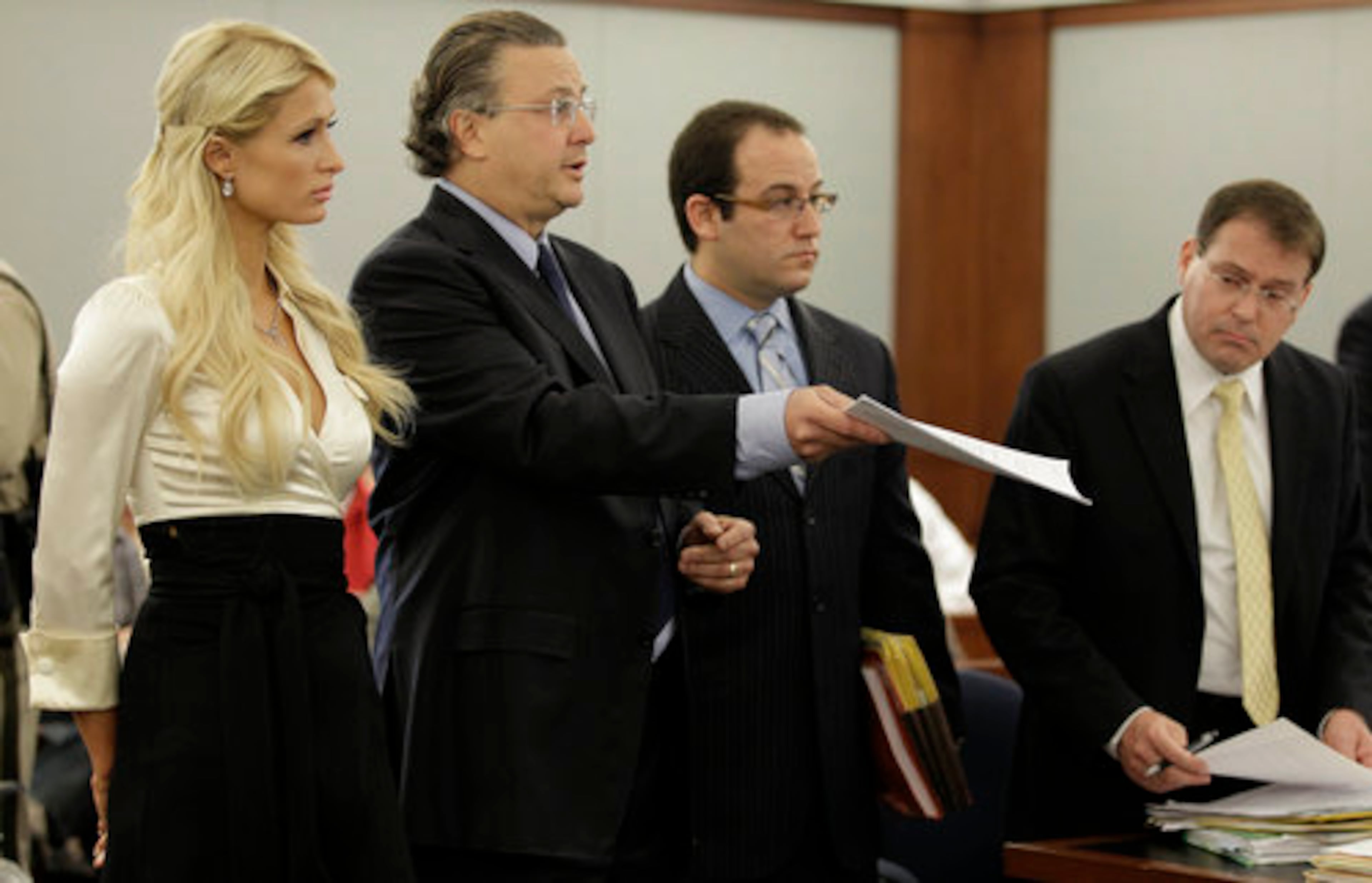 Paris Hilton listens as her attorney David Chesnoff, center, shows the plea agreement to Judge Joe Bonaventure as prosecutor David Schubert, right looks on. Hilton pleaded guilty to reduced charges in her August cocaine arrest. Under the terms of a plea deal worked out with prosecutors, the heiress will serve a year of probation and avoid a felony conviction.