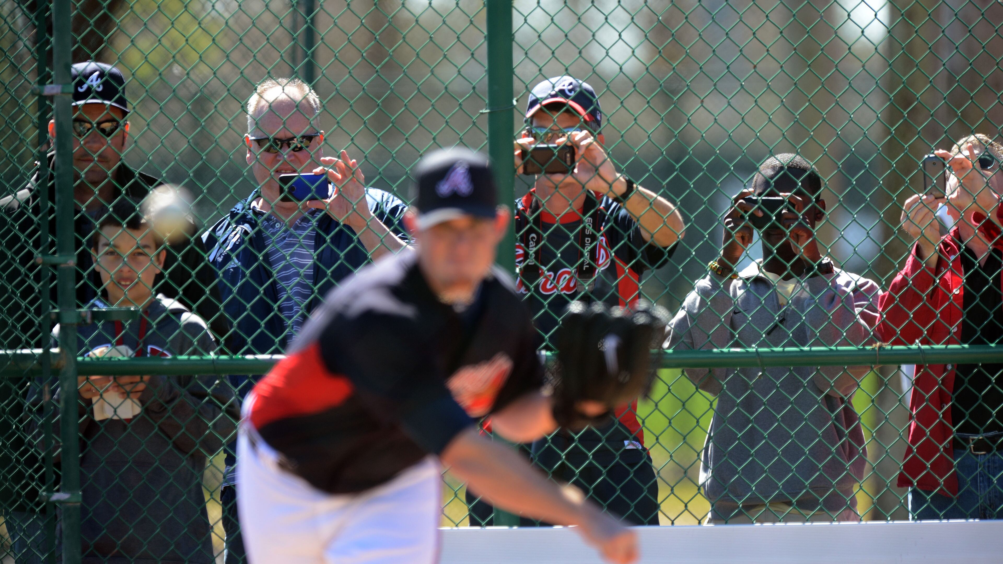 Braves fans snap pictures of Braves closer Craig Kimbrel as he works on his delivery.