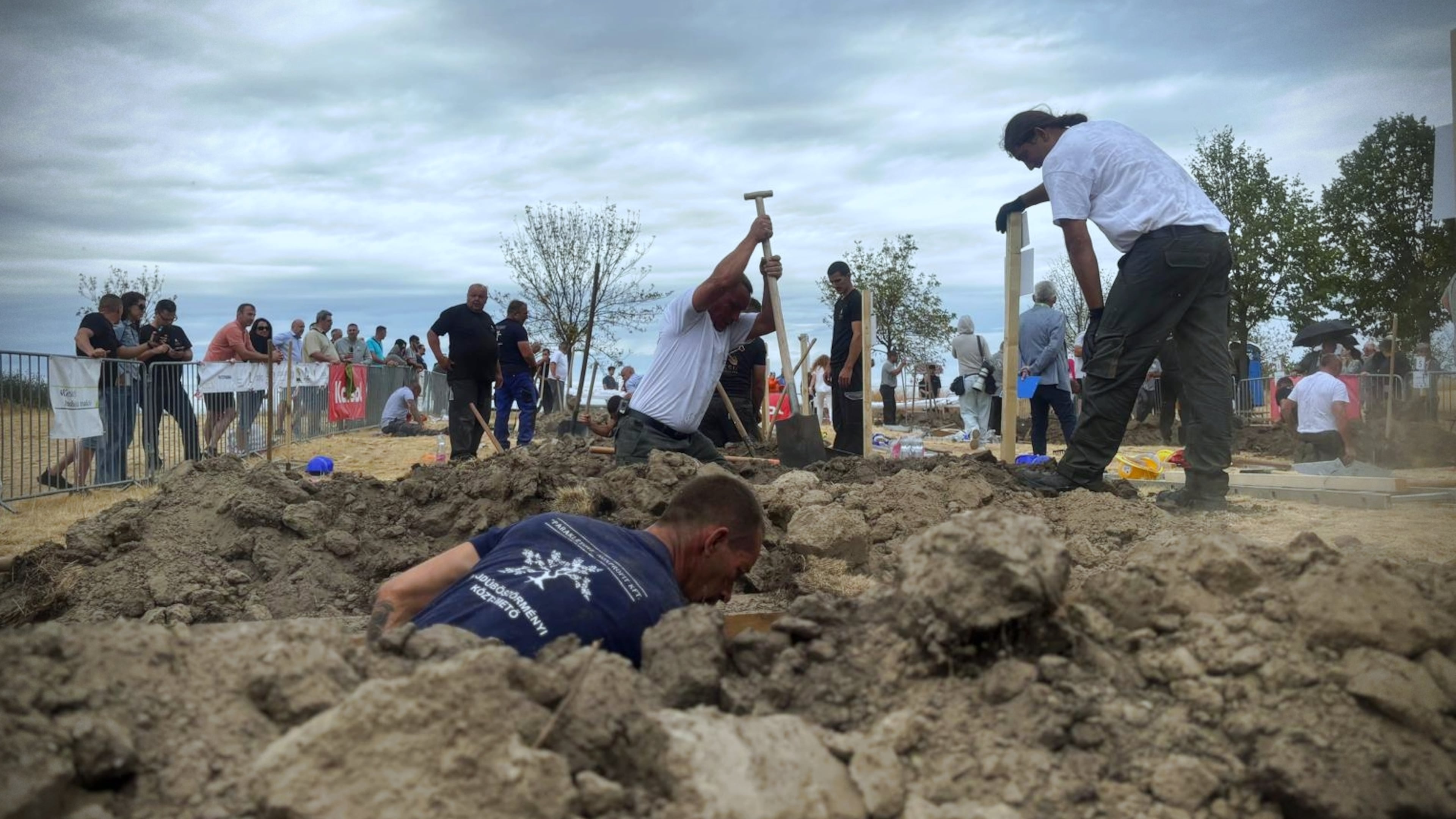 In this photo provided by Lili Szandelszky, gravediggers compete in a contest, aimed at shaking off death-related taboos, in the public cemetery of Nyergesújfalu, Hungary, Saturday, Sept. 5, 2026. (Lili Szandelszky via AP)