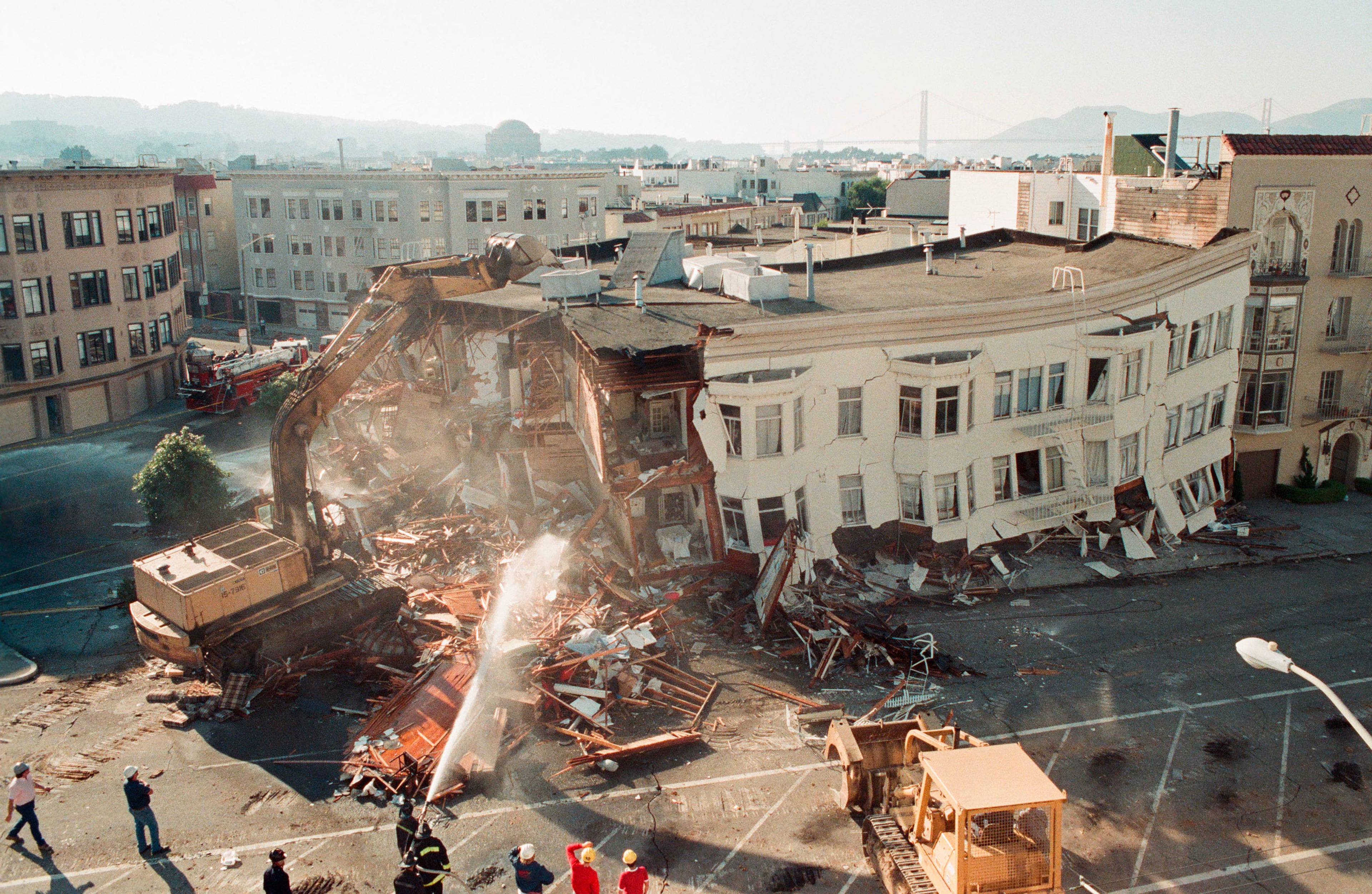 FILE : In this file photo taken Oct. 18, 1989, crews demolish a collapsed apartment building in the Marina district following the Loma Prieta earthquake in San Francisco. Friday is the 25th anniversary of the Loma Prieta earthquake that killed 63 people, injured almost 3,800 and caused up to $10 billion damage. (AP Photo/George Nikitin)