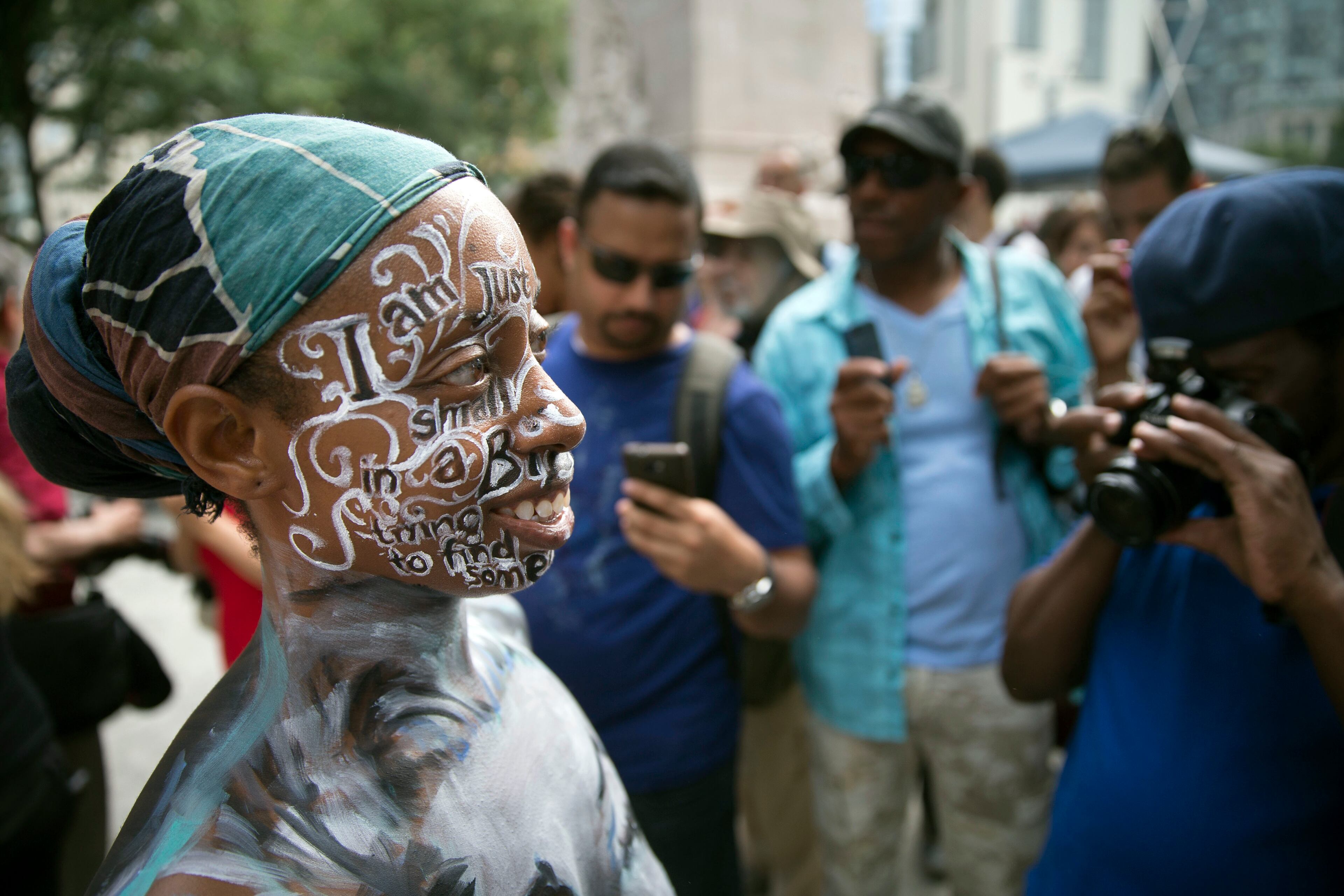 A model poses for photographs after being painted at Columbus Circle as body-painting artists gathered to decorate nude models as part of an event featuring artist Andy Golub, Saturday, July 26, 2014, in New York. Golub says New York was the only city in the country that would allow his inaugural Bodypainting Day. (AP Photo/John Minchillo)