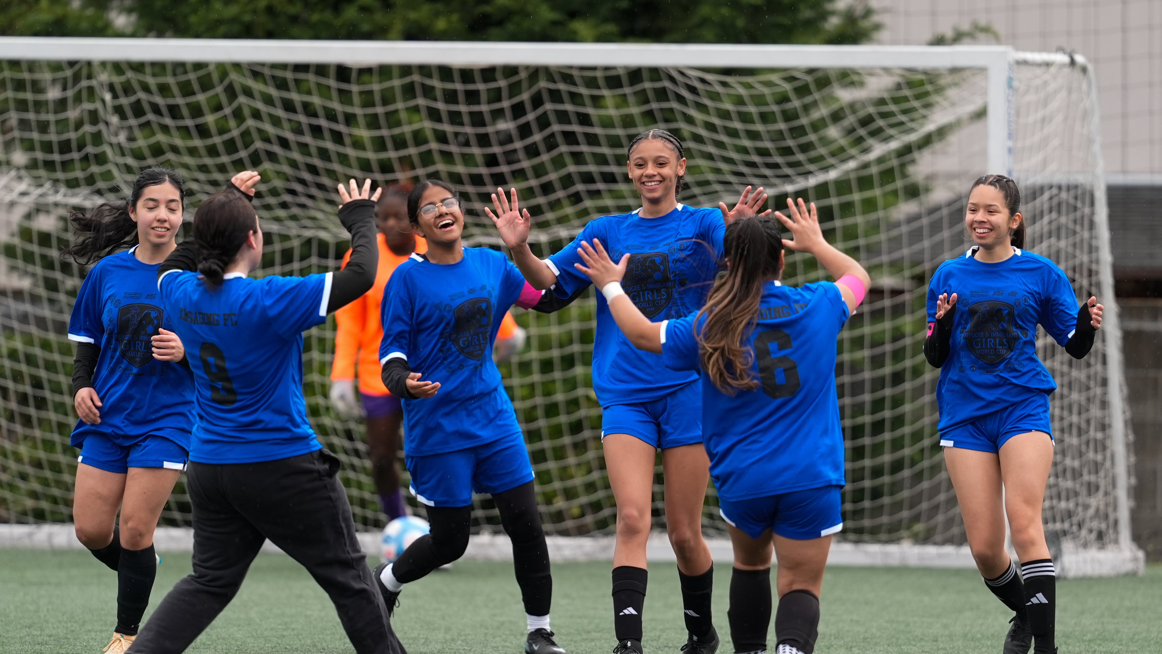Aubrey Decraig, third from right, celebrates with teammates after scoring a goal during a soccer tournament for immigrant and refugee girls on Sunday, March 29, 2026, in Portland, Ore. (AP Photo/Jenny Kane)