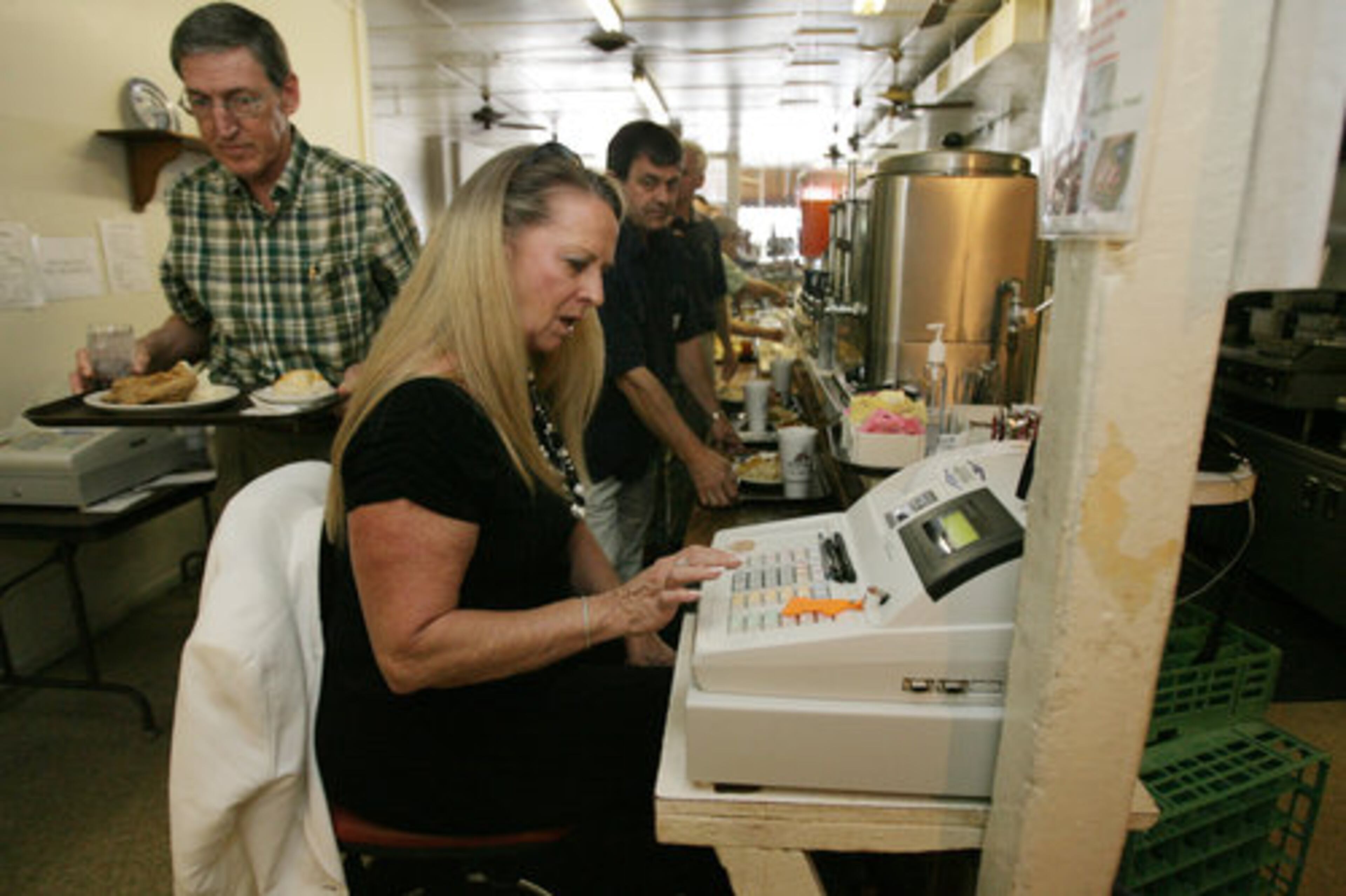 Office manager Nancy Lewis running the cash register during the lunch rush. At its peak, the line can be 25 people deep.