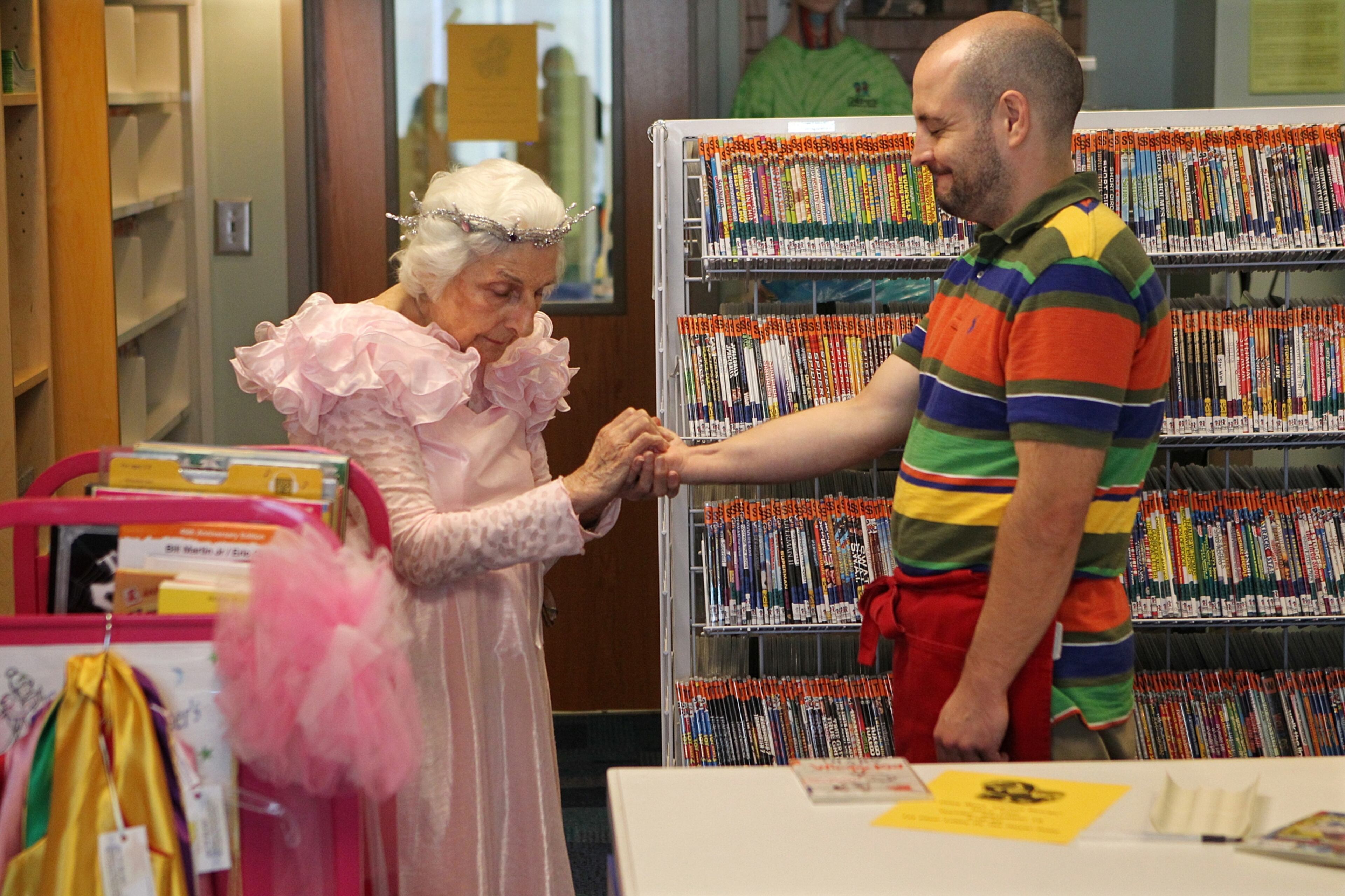 Even fellow volunteers can use a wish. Fokes Link, 34, who has volunteered for two years in the children's library, closes his eyes while Viener places a piece of imaginary fairy dust in his hand.