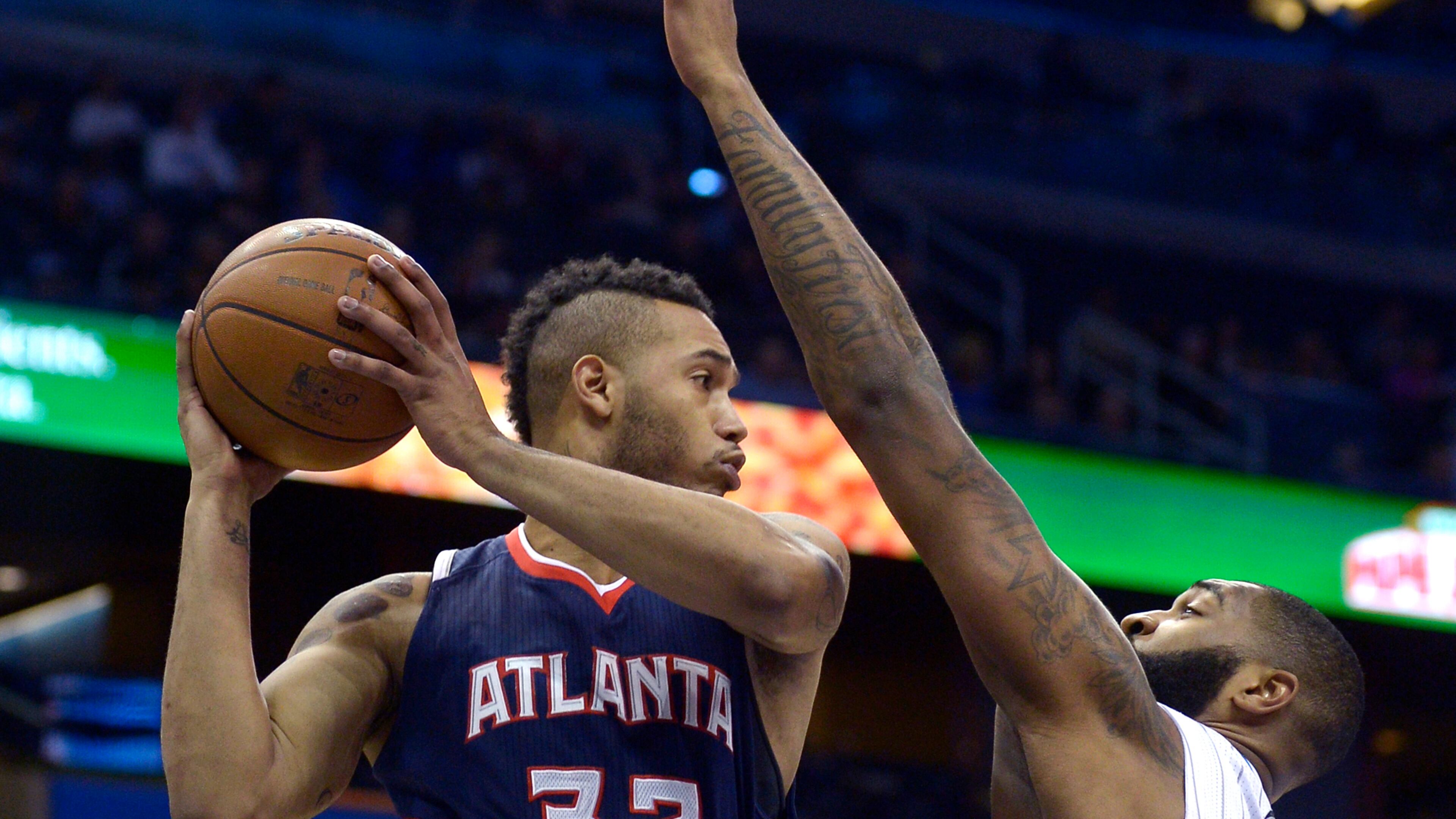 Atlanta Hawks forward Mike Scott (32) looks to pass in front of Orlando Magic forward Kyle O'Quinn during the first half of an NBA basketball game in Orlando, Fla., Wednesday, Jan. 22, 2014.