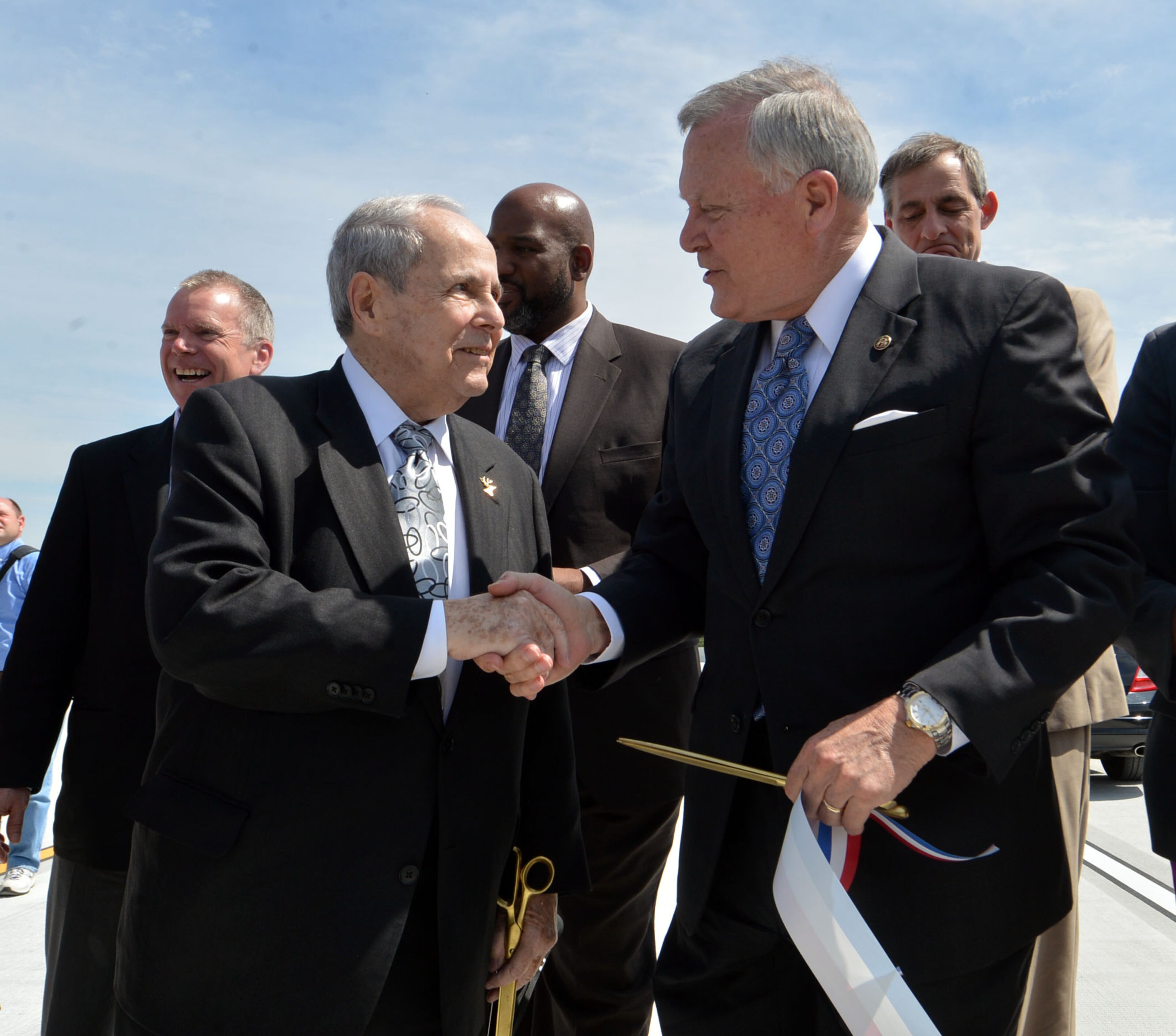 Governor Nathan Deal shakes hands with former Atlanta Mayor Sam Massell. Deal and other state and local leaders conducted a brief ribbon-cutting celebration of the opening of the new flyover ramps Wednesday, April 2, 2014. The ramps provide I-85 southbound traffic with direct access to GA 400 northbound and also give GA 400 southbound motorists a direct ramp to I-85 northbound.