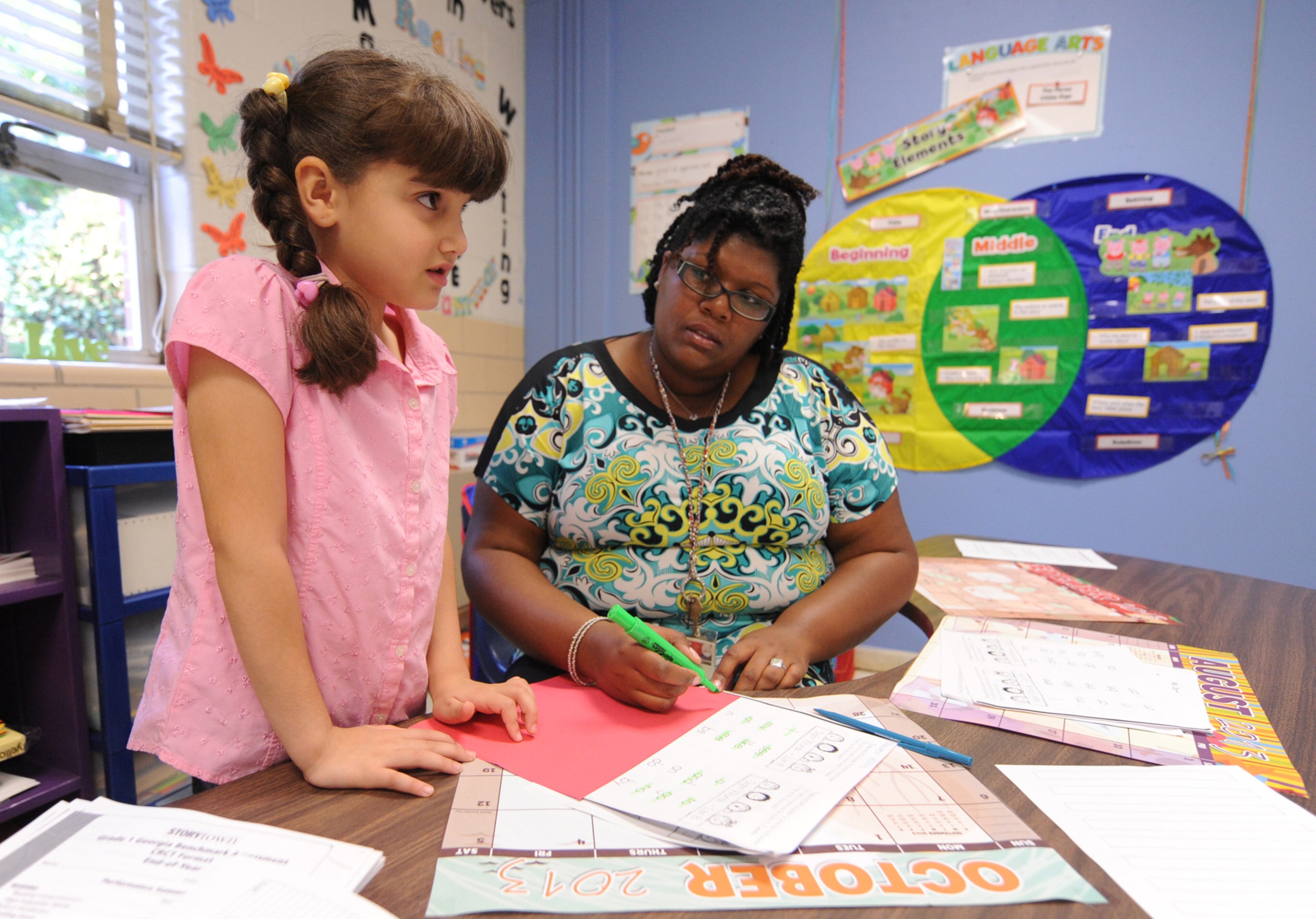 Maisoon Abu Atwan concentrates as she answers questions from her first grade teacher, Maegan Donnell, on the first day of school at Midvale Elementary on Monday, August 12, 2013. JOHNNY CRAWFORD / JCRAWFORD@AJC.COM