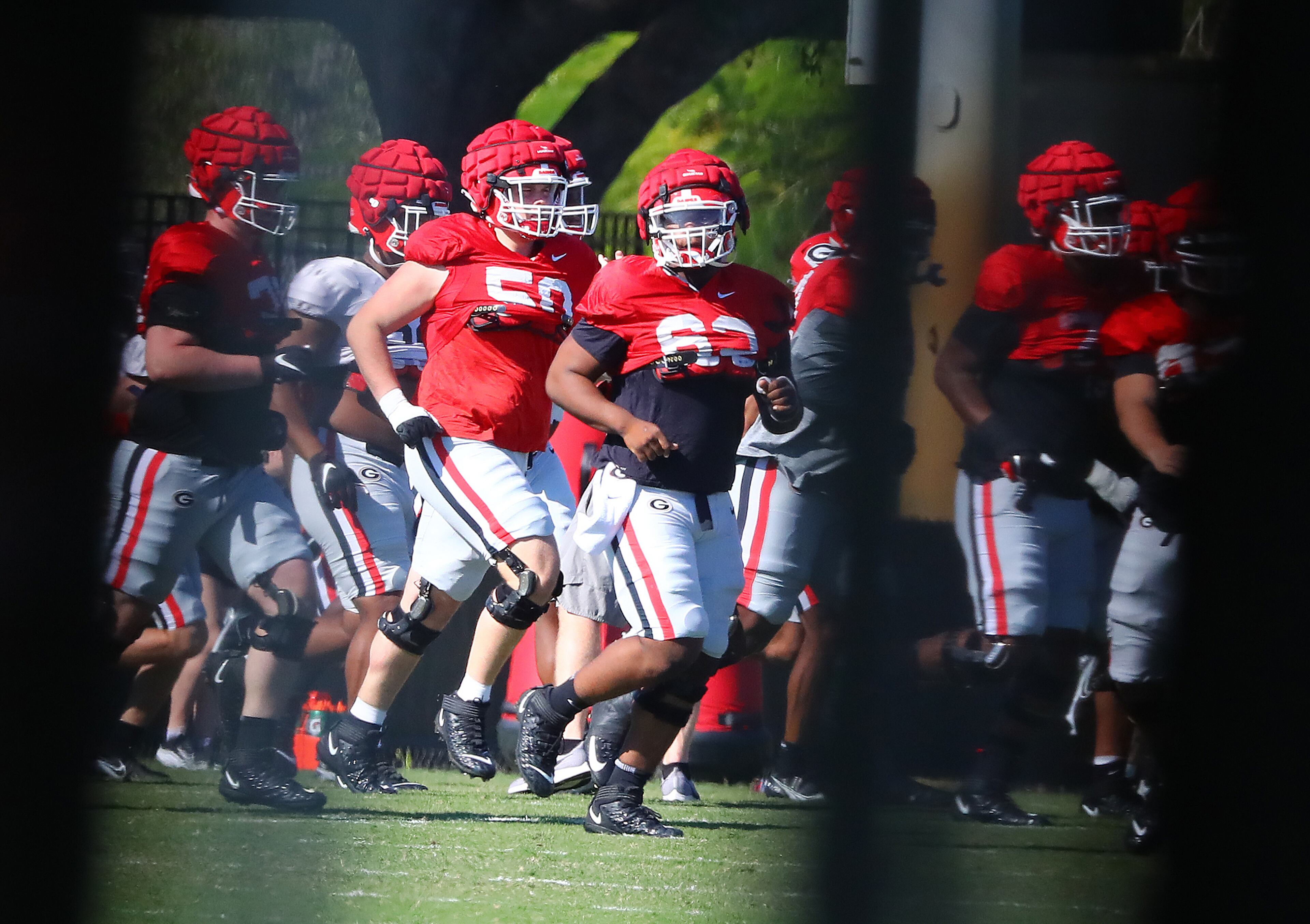 122721 Miami Shores: Georgia offensive lineman (50) Warren Ericson and (63) Sedrick Van Pran run with teammates to the next drill during team practice at Barry University on Monday, Dec 27, 2021, in Miami Shores. Georgia plays Michigan at 7:30 p.m. on Friday at Hard Rock Stadium in Miami Gardens, Fla., in the Orange Bowl CFP Semifinal. “Curtis Compton / Curtis.Compton@ajc.com”`
