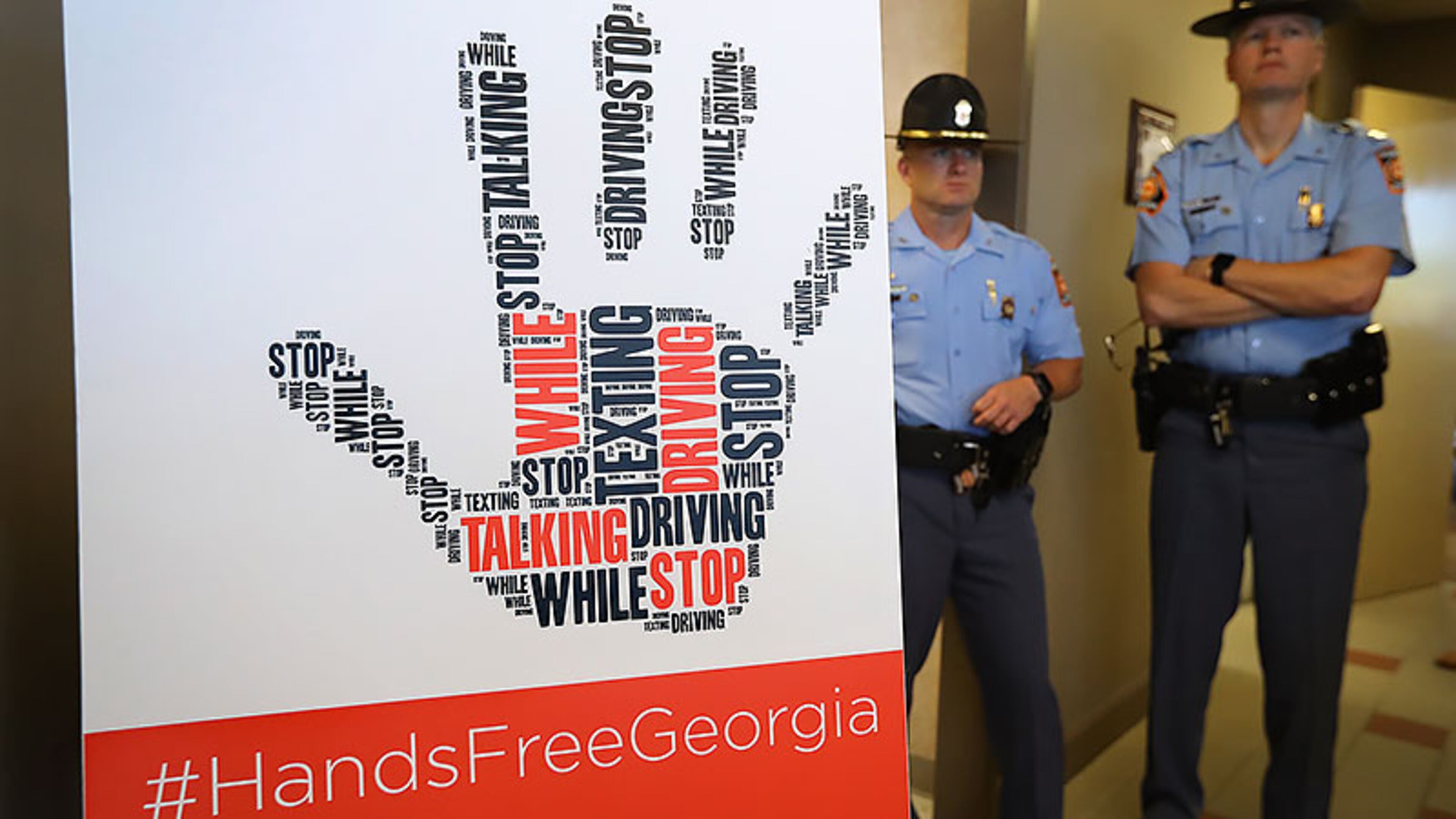 Georgia State Patrol officers, who will be enforcing the law, attend a ceremony where Gov. Nathan Deal signed the Hands-Free Georgia Act. The law is designed to curb distracted driving.