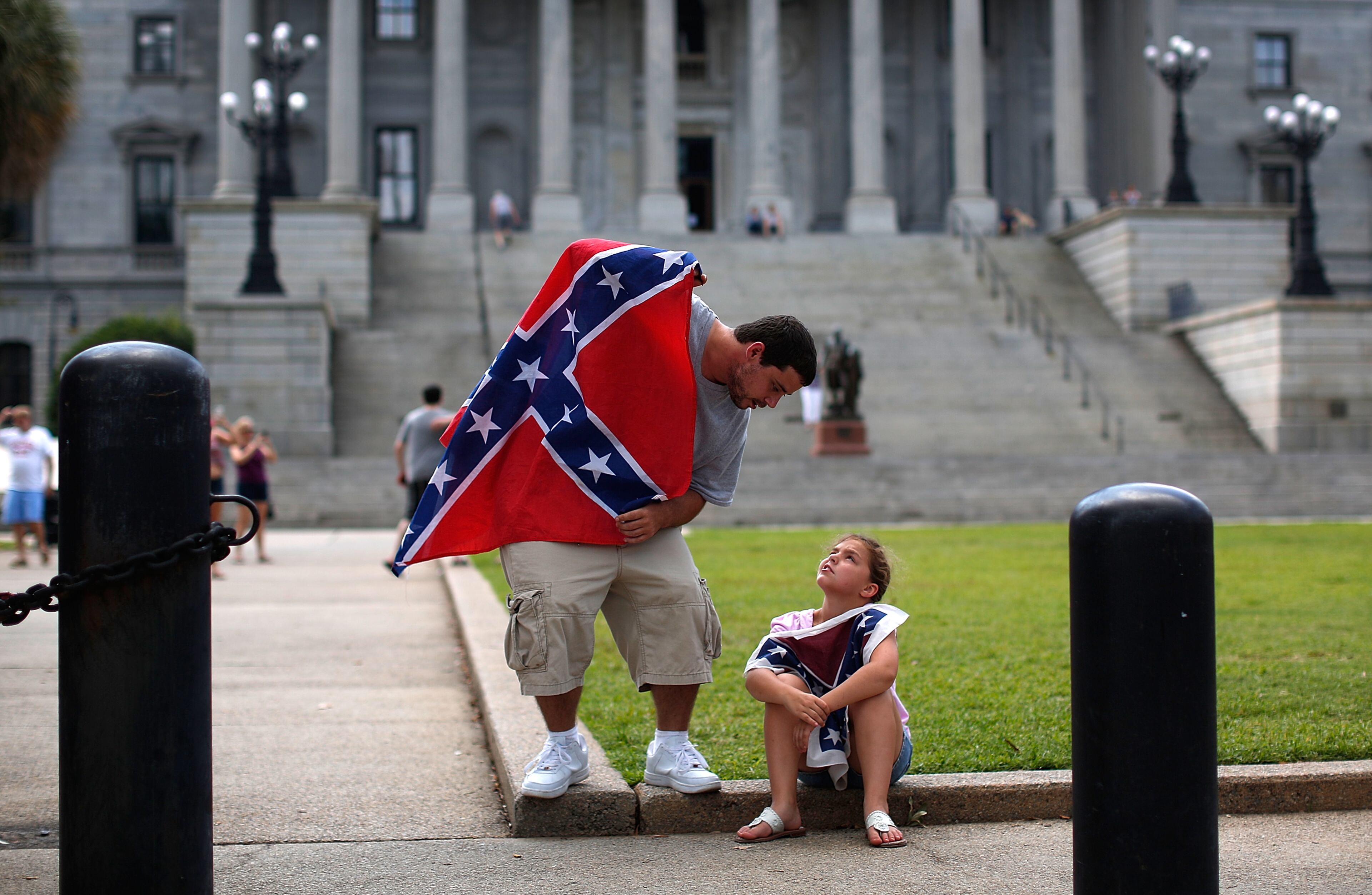 COLUMBIA, SC - JUNE 27: Hugh Crawford of Lexington, South Carolina speaks with his daughter Holli Crawford, age 7, as they join a group of demonstrators on the grounds of the South Carolina State House calling for the Confederate flag to remain on the State House grounds June 27, 2015 in Columbia, South Carolina. Earlier in the week South Carolina Gov. Nikki Haley expressed support for removing the Confederate flag from the State House grounds in the wake of the nine murders at Mother Emanuel A.M.E. Church in Charleston, South Carolina. (Photo by Win McNamee/Getty Images)