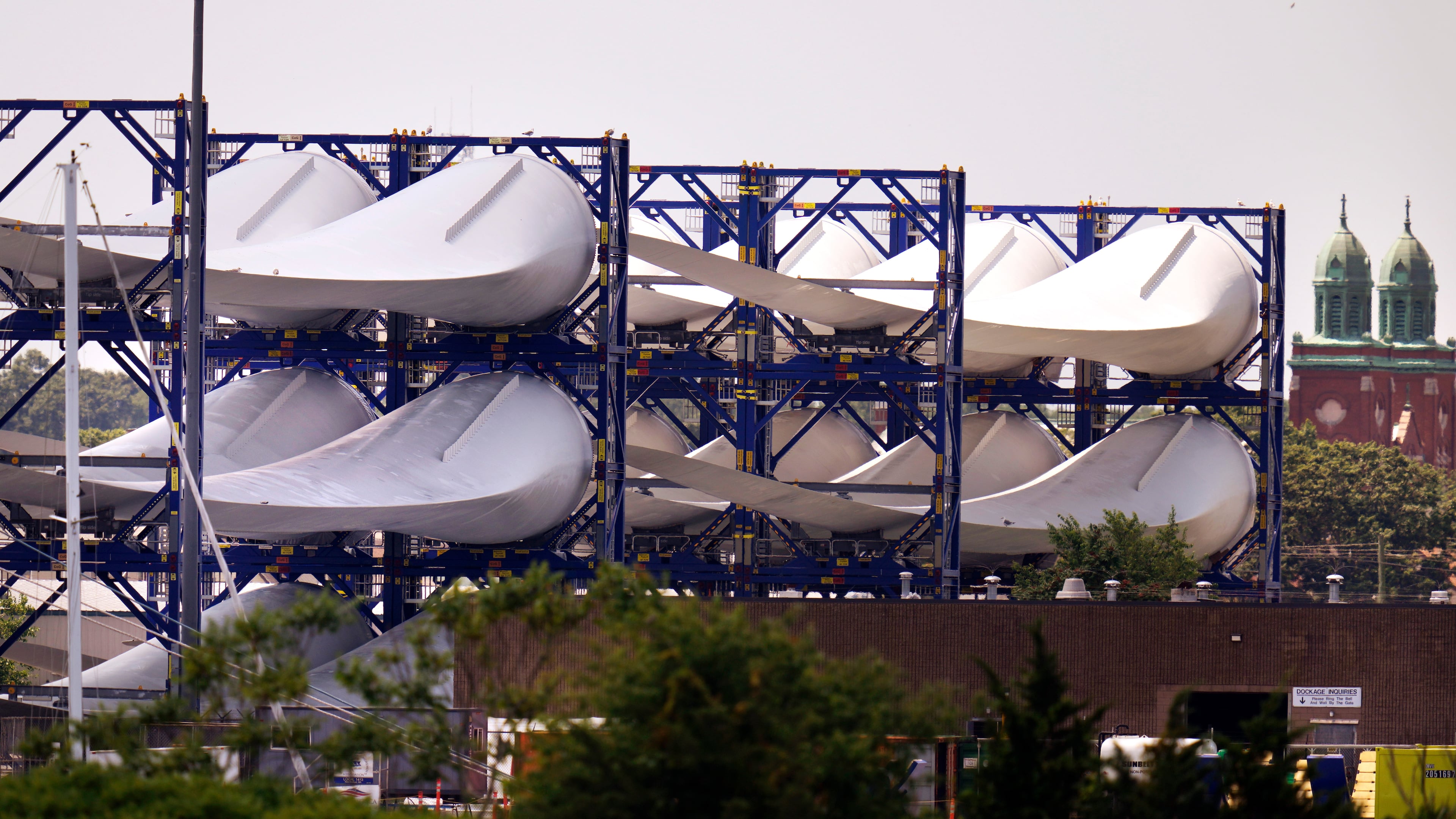 FILE - Giant wind turbine blades for the Vineyard Winds project are stacked on racks in the harbor, July 11, 2023, in New Bedford, Mass. (AP Photo/Charles Krupa, File)