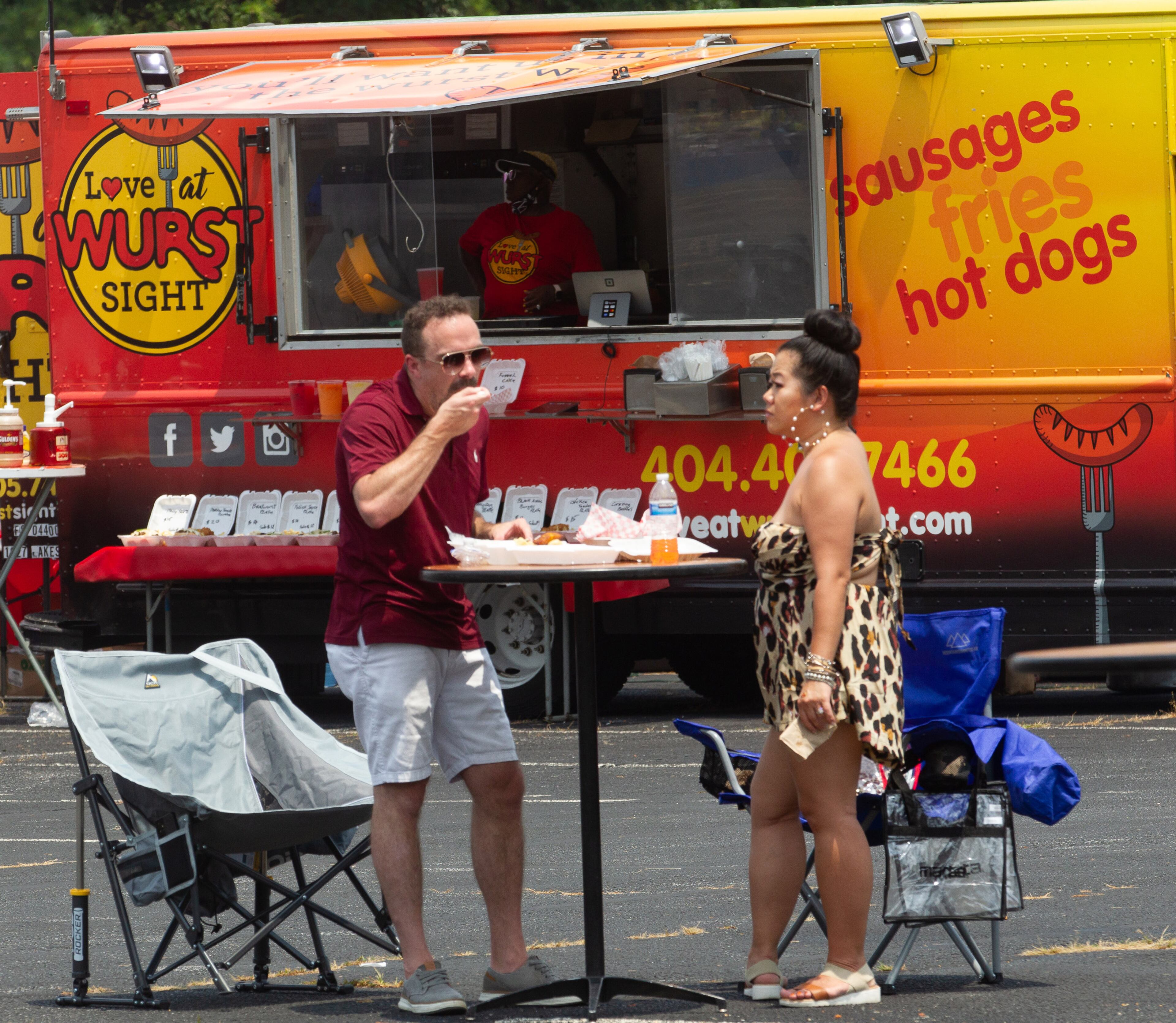 Jason Watts and Kiki Mua eat lunch from one of the food trucks during the Brookhaven Cherry Blossom Festival on Saturday, July 31, 2021. STEVE SCHAEFER FOR THE ATLANTA JOURNAL-CONSTITUTION