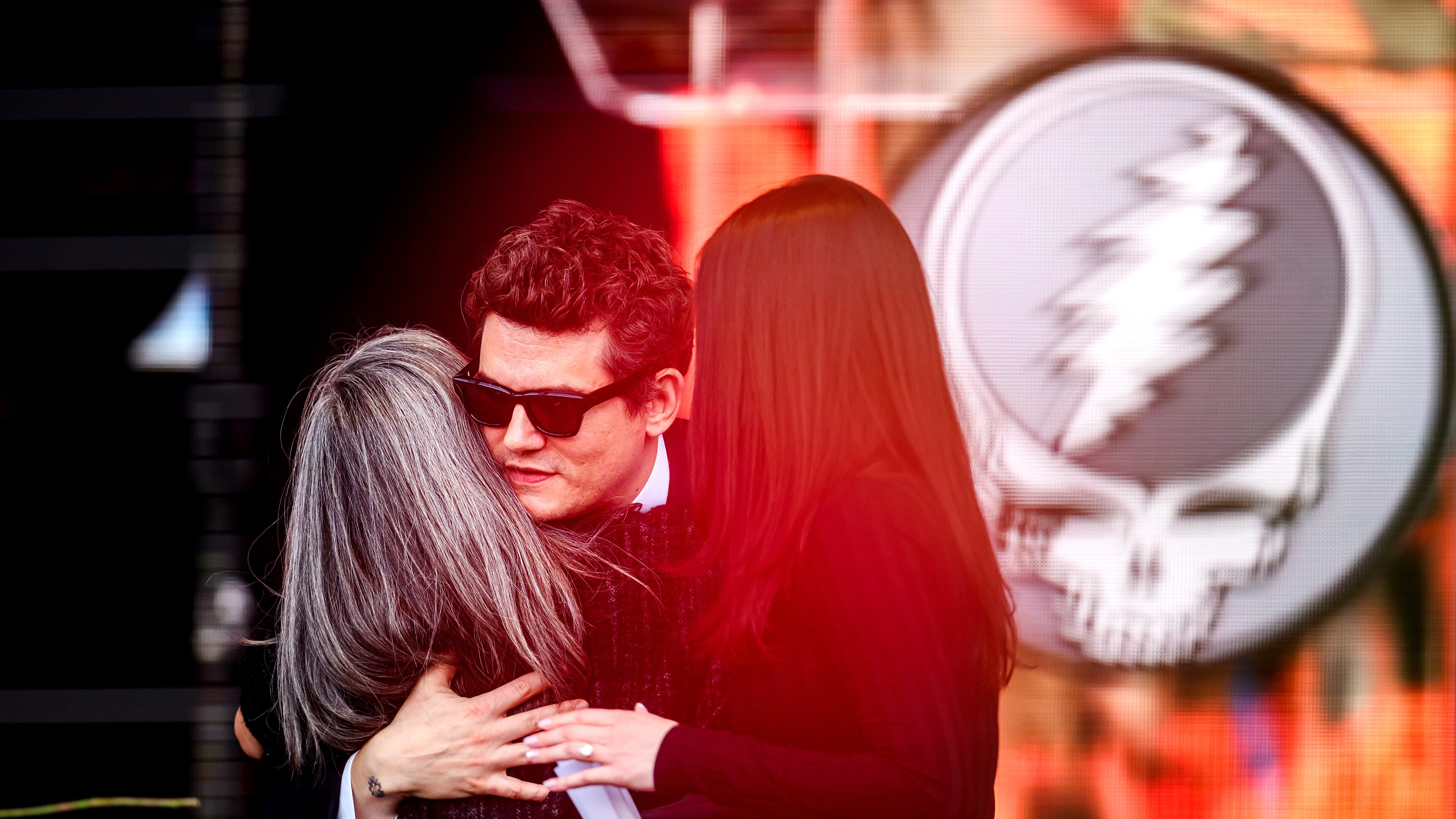 John Mayer embraces Natascha Münter during a public memorial for her husband, Grateful Dead guitarist Bob Weir, on Saturday, Jan. 17, 2026, in San Francisco. (AP Photo/Noah Berger)
