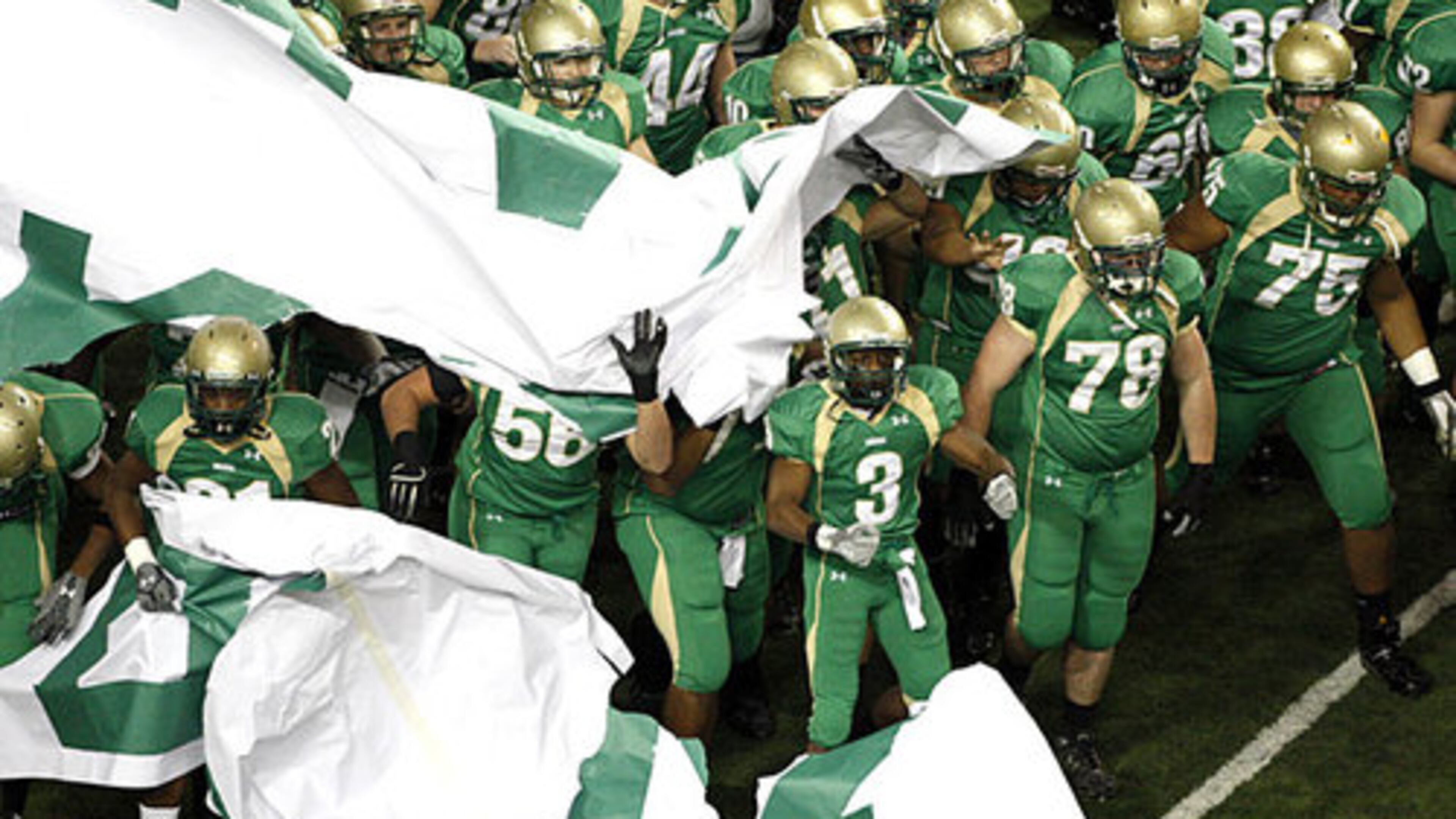 The Buford Wolves crash through a banner to announce their arrival.