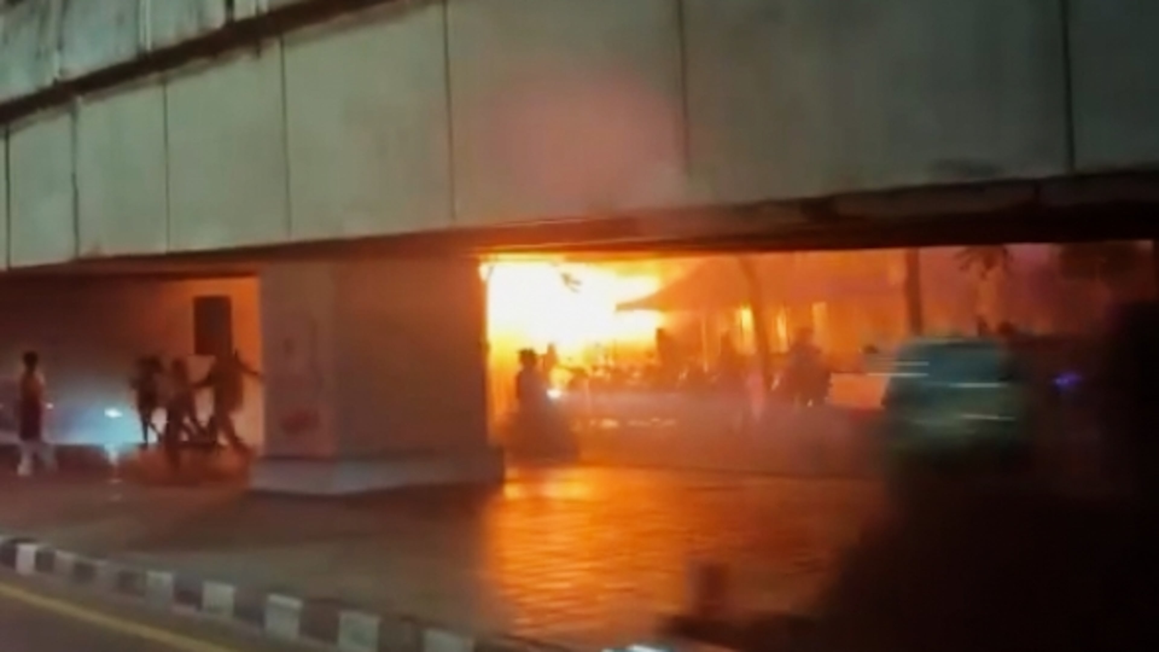 In this image made from video provided by Instagram handle @jackfanchan, people move around a fire at a bar in Bangkok, Thailand, Monday, July 13, 2026. (@jackfanchan via AP)