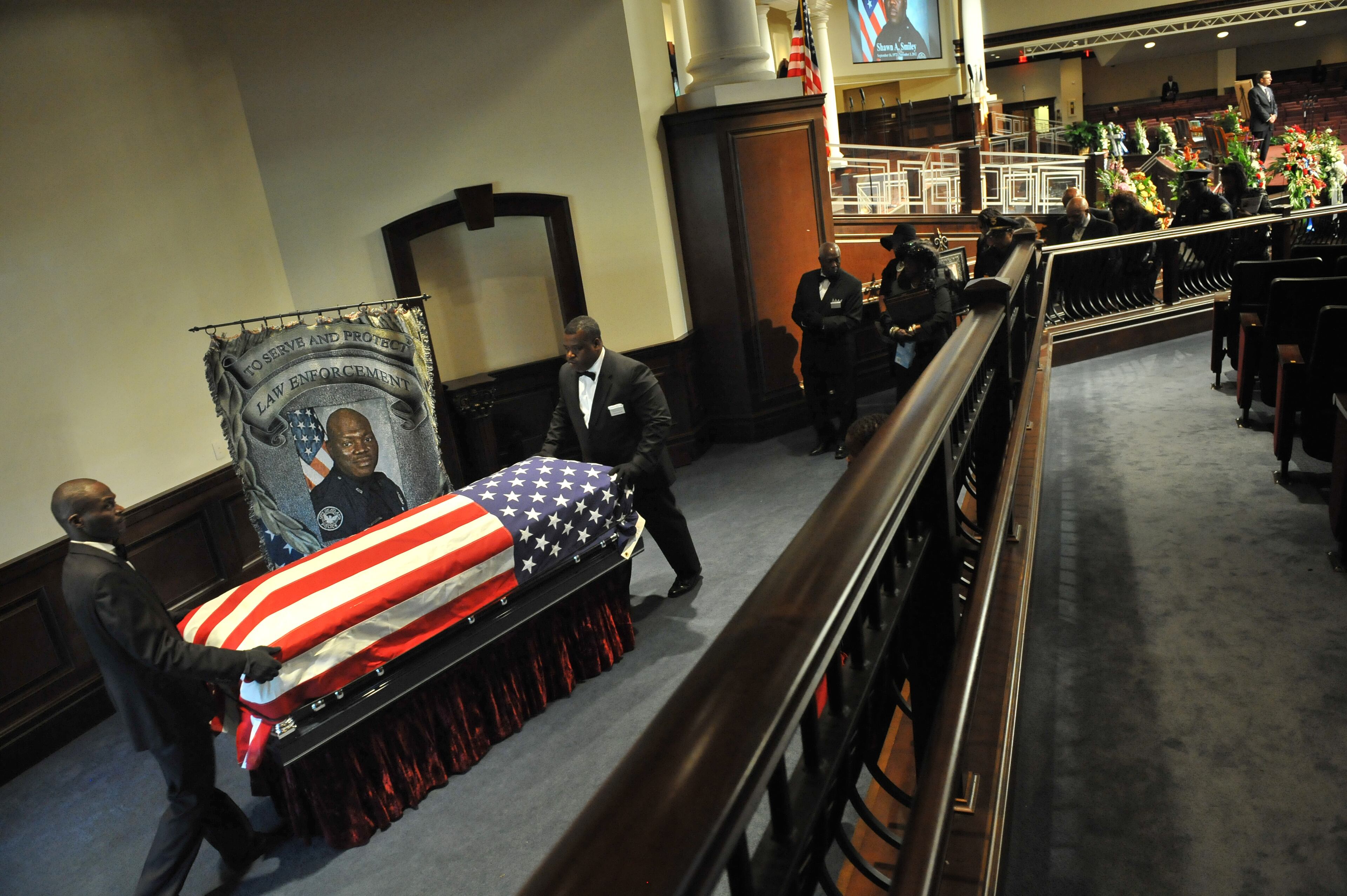 The casket is carried by funeral staff during APD Officer Shawn Smiley's funeral at First Baptist Church of Atlanta on Saturday, November 10, 2012. APD Officer Shawn Smiley was in the passenger seat last weekend when an APD helicopter searching for a missing 9-year-old boy crashed in Atlanta. HYOSUB SHIN / HSHIN@AJC.COM