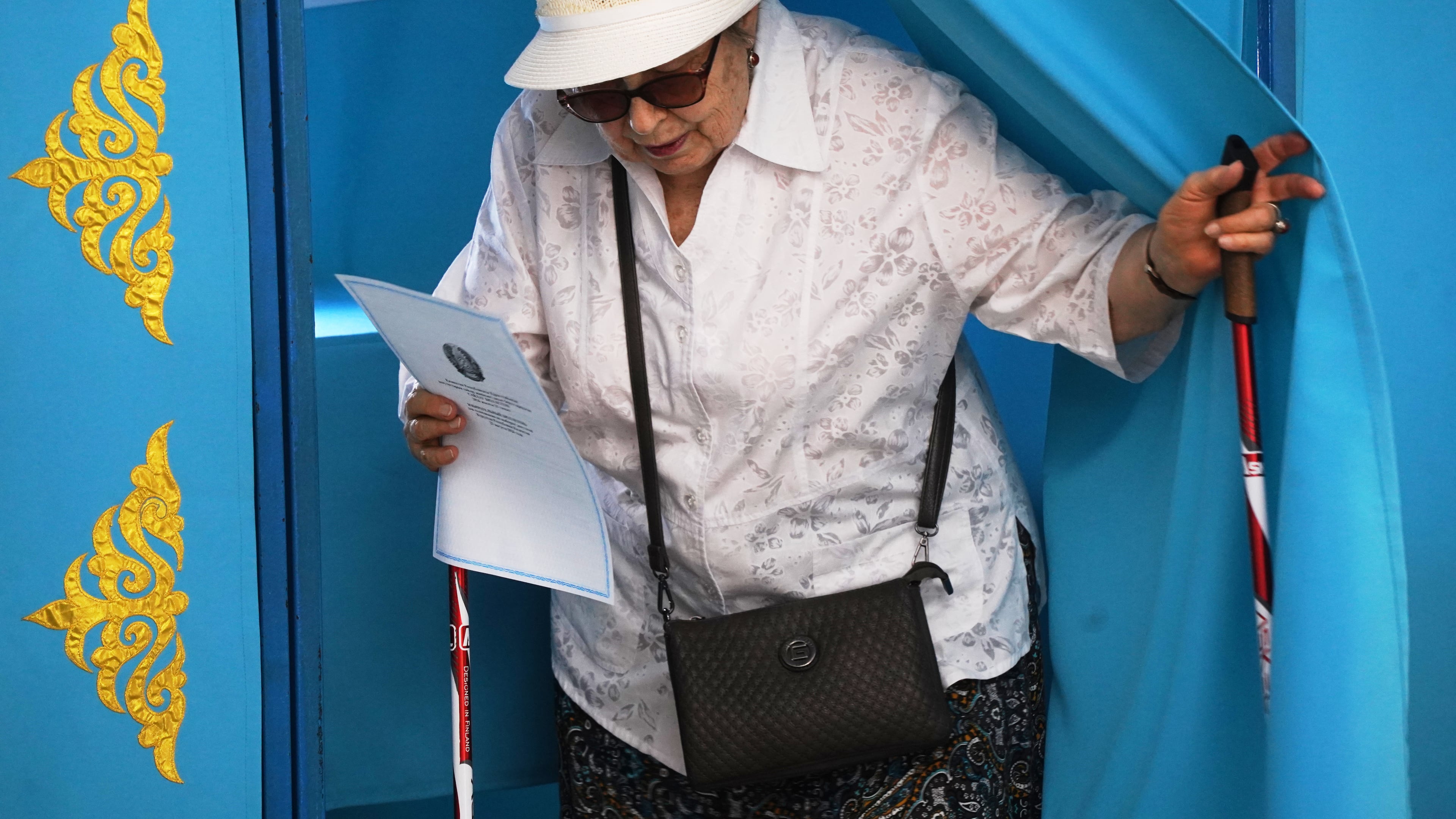 A woman leaves a booth to cast her vote at a polling station during early parliamentary elections in Almaty, Kazakhstan, Sunday, Aug. 23, 2026. (AP Photo/Vladimir Tretyakov)