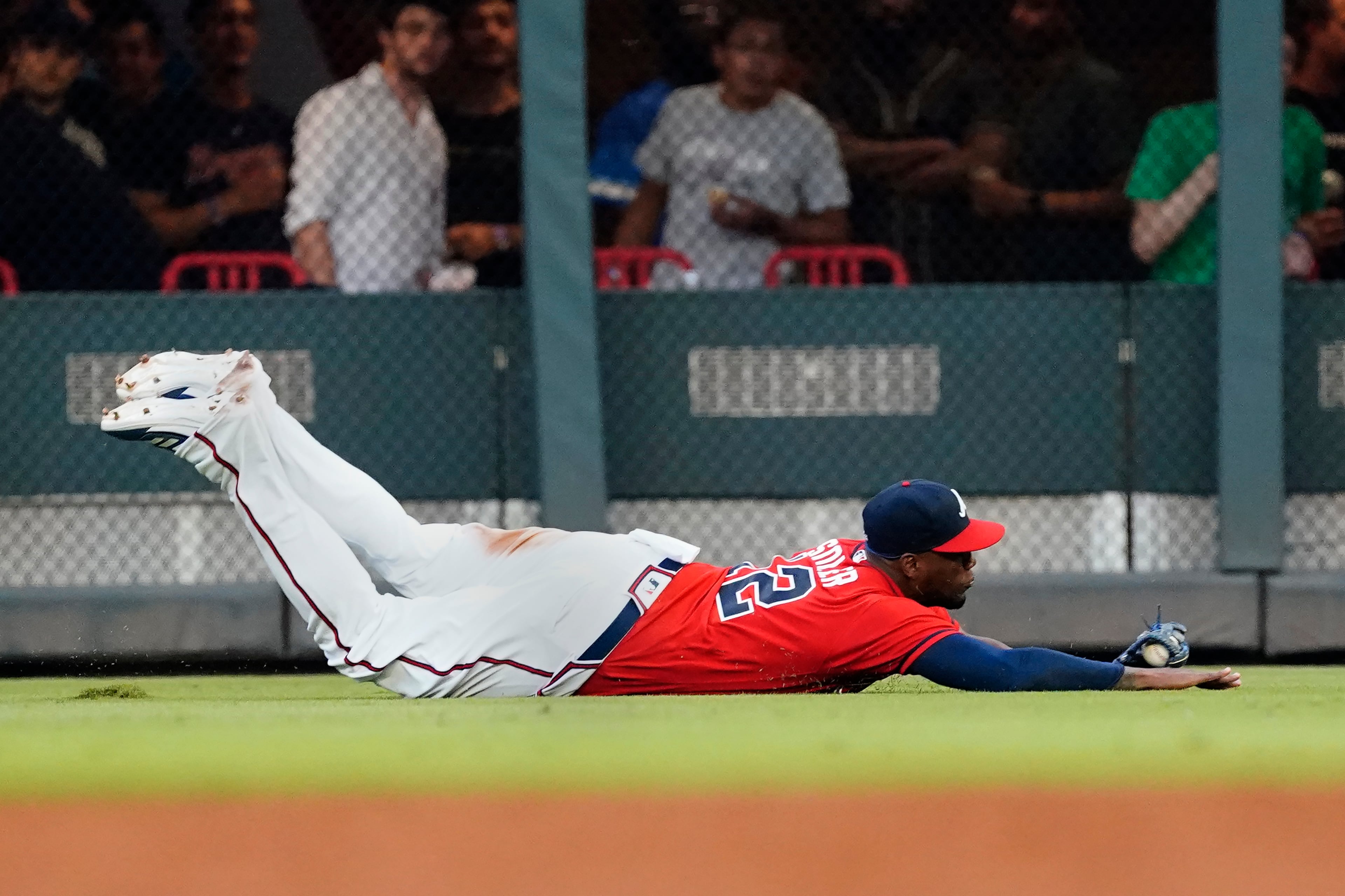 Atlanta Braves right fielder Jorge Soler (12) makes a diving catch on a fly ball by Washington Nationals' Gerardo Parra in the fourth inning of a baseball game Friday, Aug. 6, 2021, in Atlanta. (AP Photo/John Bazemore)