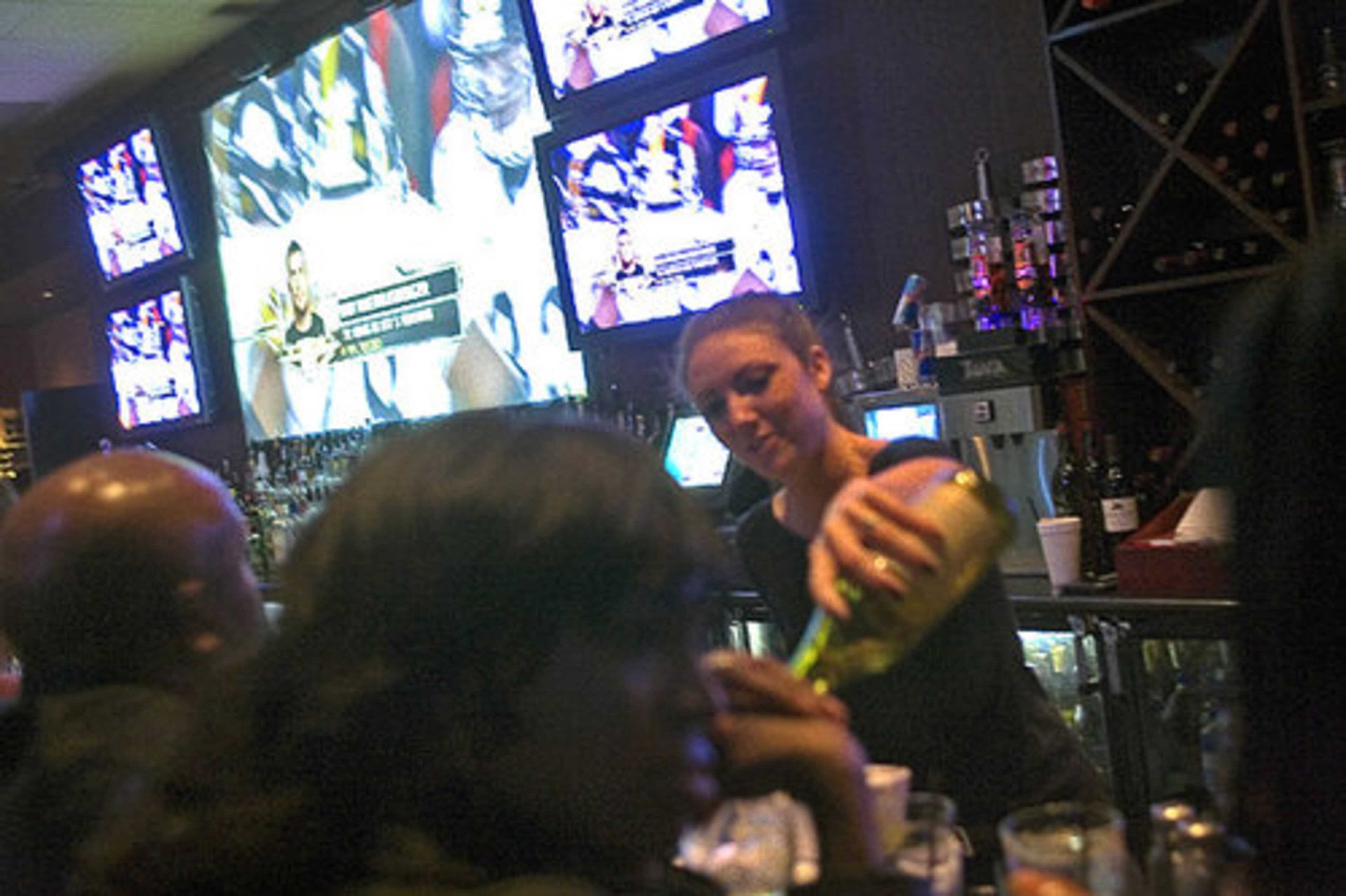Bartender Shelby Yandell pours drinks at Dantanna's in Atlanta as patrons watch the Pittsburgh Steelers play the Arizona Cardinals in Super Bowl XLIII on Sunday, Feb. 1, 2009.