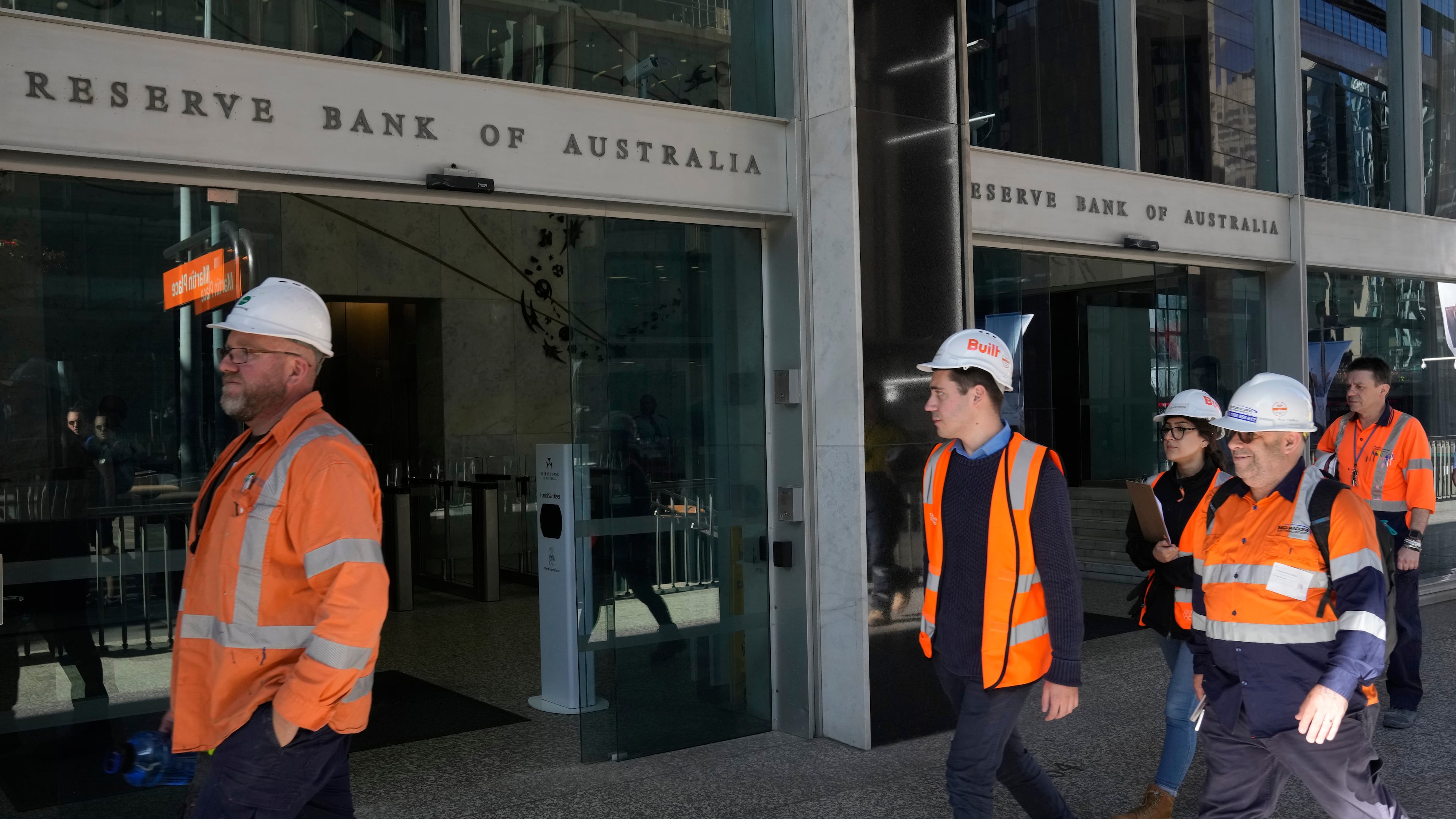 FILE - Workers in high visibility clothing walk past the Reserve Bank of Australia in Sydney, Nov. 1, 2022. (AP Photo/Rick Rycroft, File)