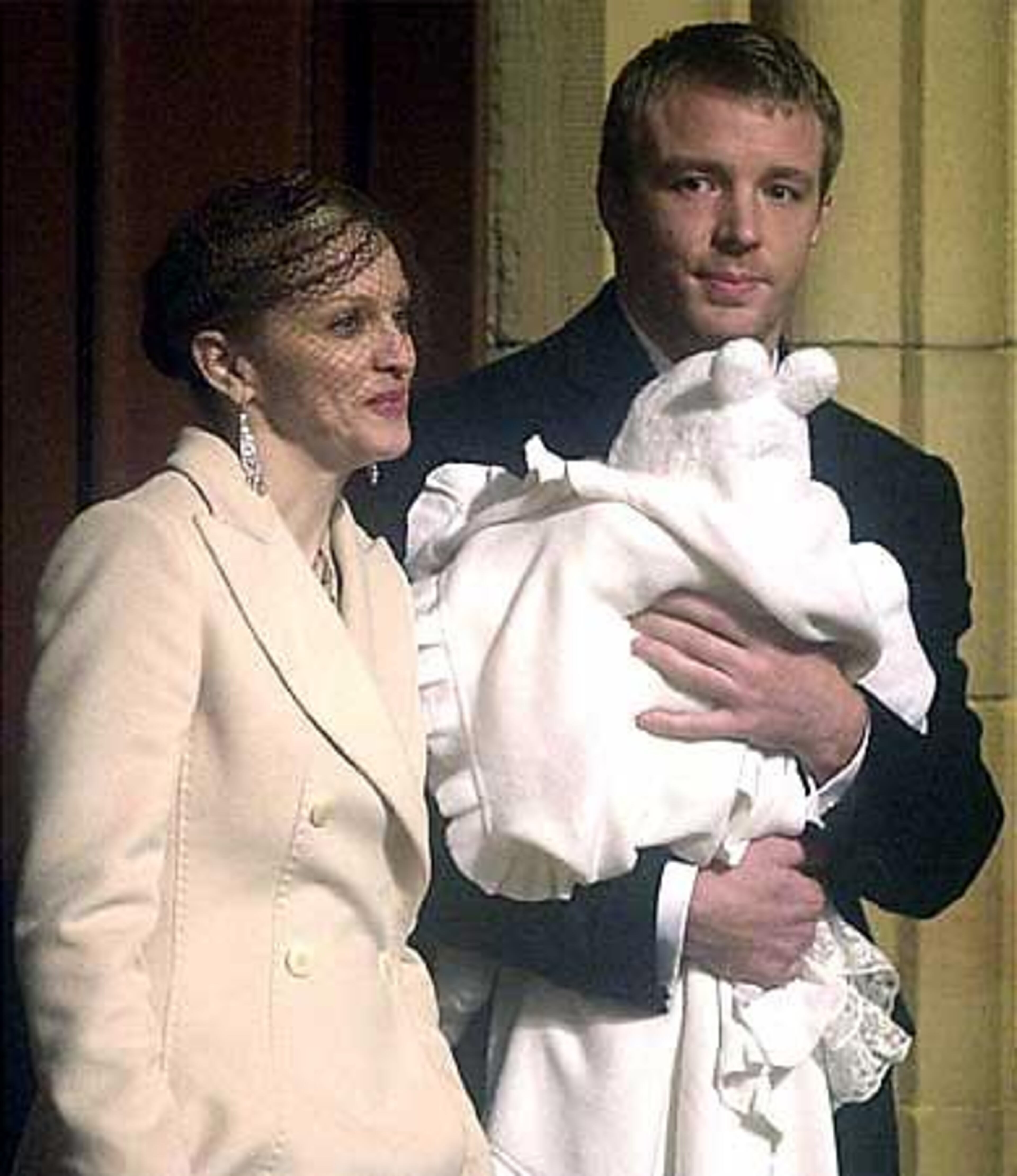Pop star Madonna stands next to Guy Ritchie as he carries their son Rocco outside of Dornoch Cathedral, in northern Scotland, in December 2000, following Rocco's baptism. Madonna and the British film director were married a short time later.