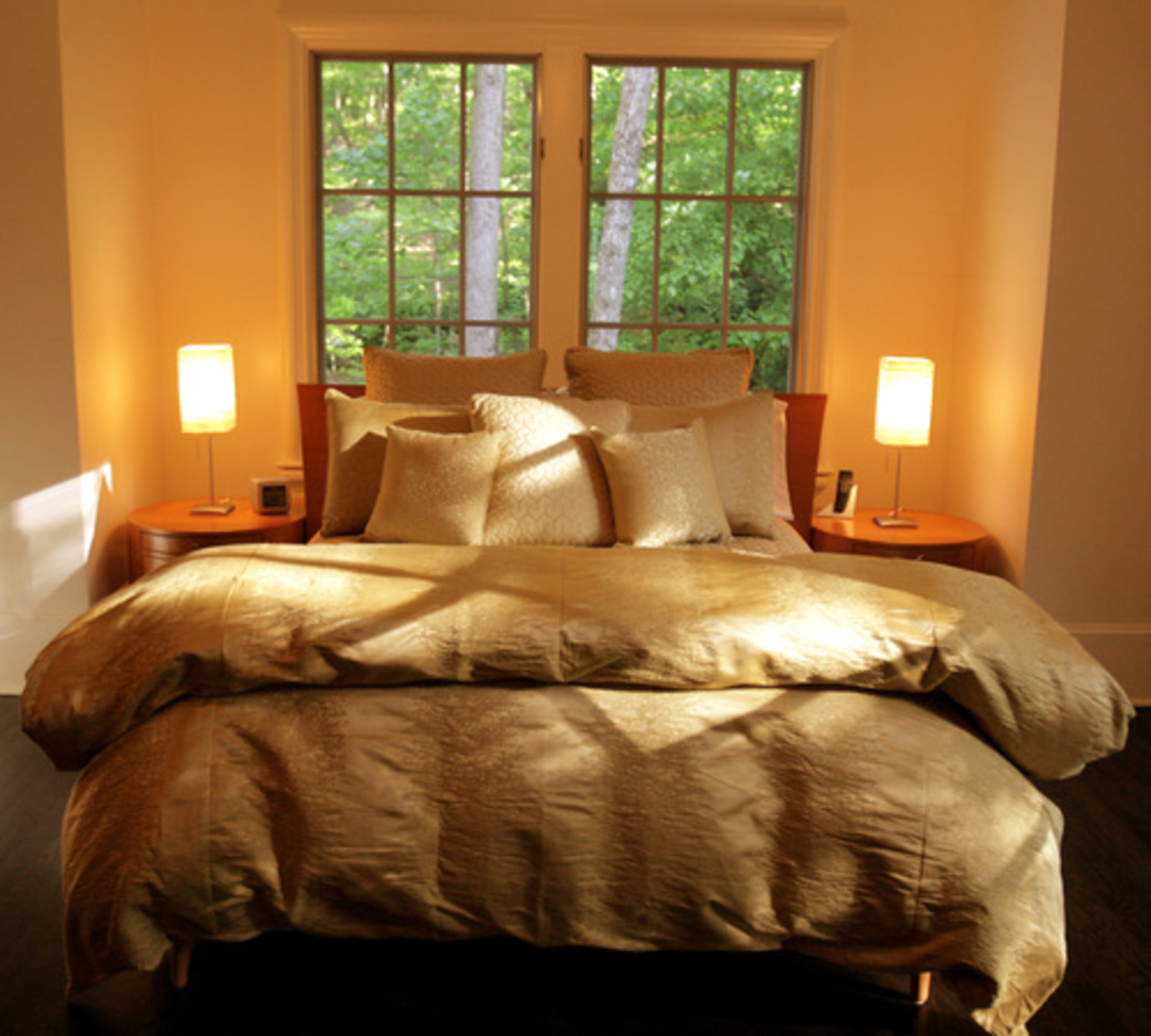 In keeping with the metallic motif of the master suite, this guest room is outfitted in gold accents. The wooded privacy of the property eliminates the need for curtains or shades. Pearson prefers an unobstructed view, he said.
