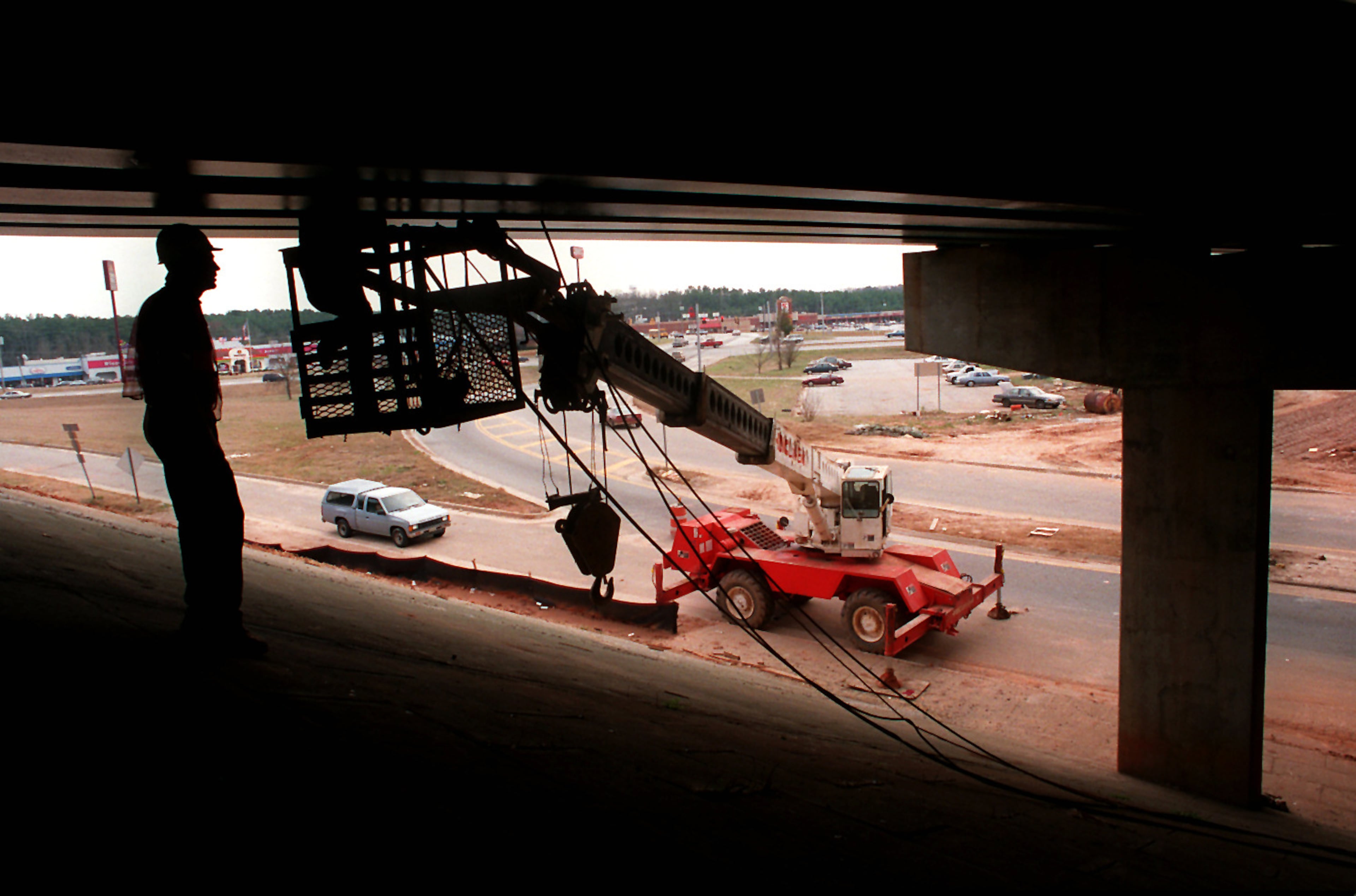 COVINGTON Charles Cantrell 56 left and Charles Hall 53 in basket somewhat obscured from view work on secondary braces under the I 20 overpass at the Covington Oxford exit on I 20 at 278 as part of renovation expansion project on Thursday Feb 23 1995