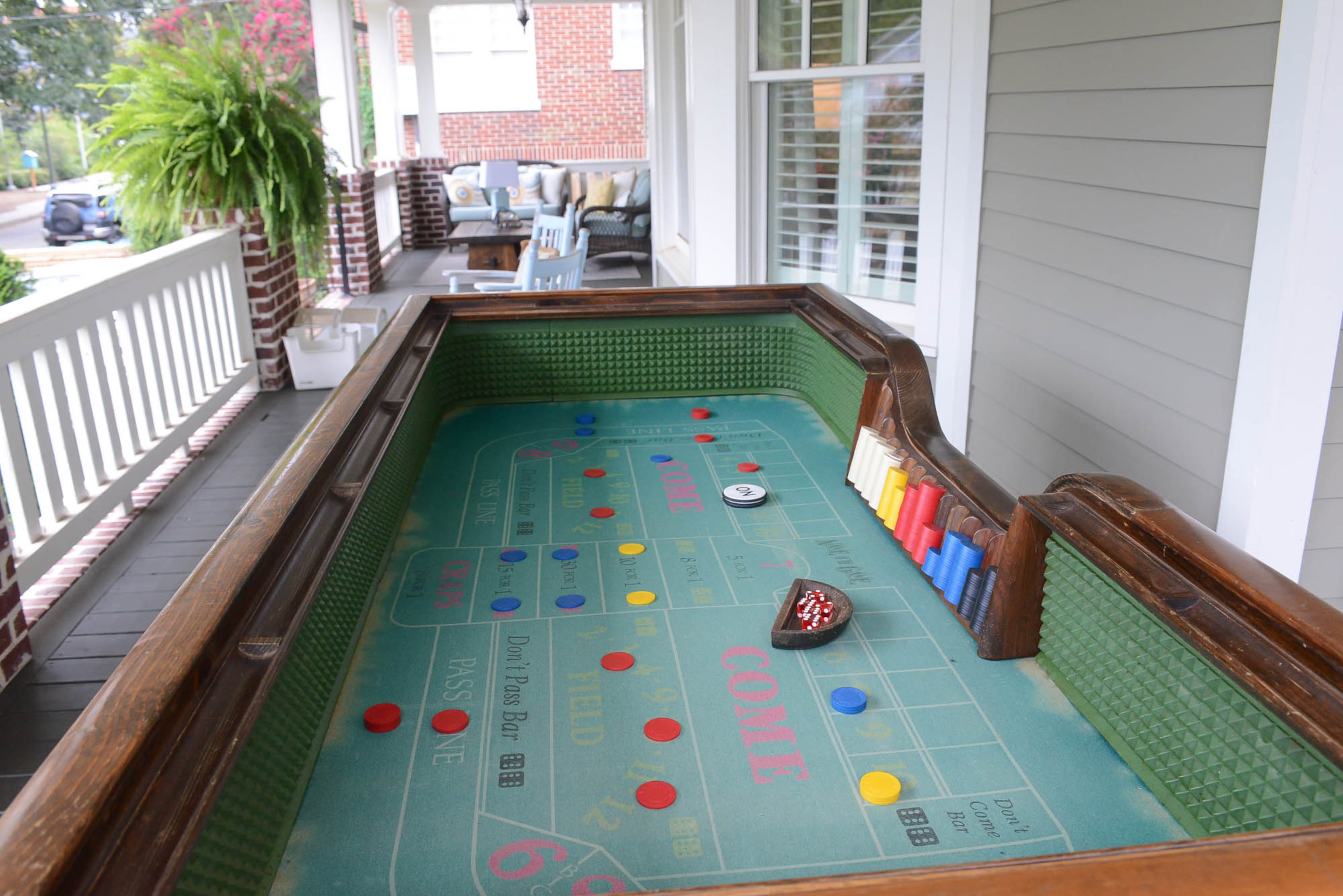 A casino craps table that Dave bought on Craigslist sits on the wraparound front porch.